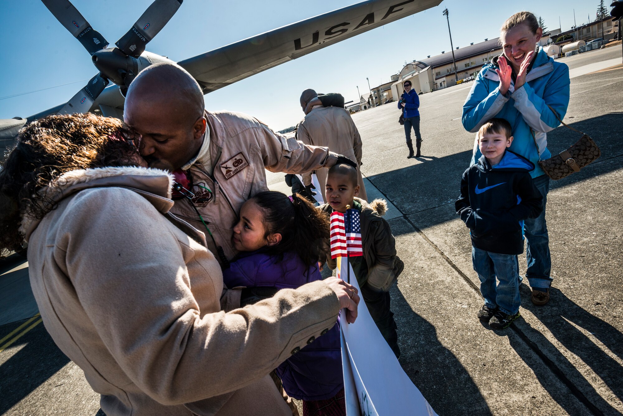 YOKOTA AIR BASE, Japan -- Staff Sgt. Javier Lindsay, 374th Aircraft Maintenance Squadron, kisses his wife and hugs his children at Yokota Air Base, Japan, Jan. 19, 2013. Lindsay had just returned from deployment to Southwest Asia. (U.S. Air Force photo by Tech. Sgt. Samuel Morse)