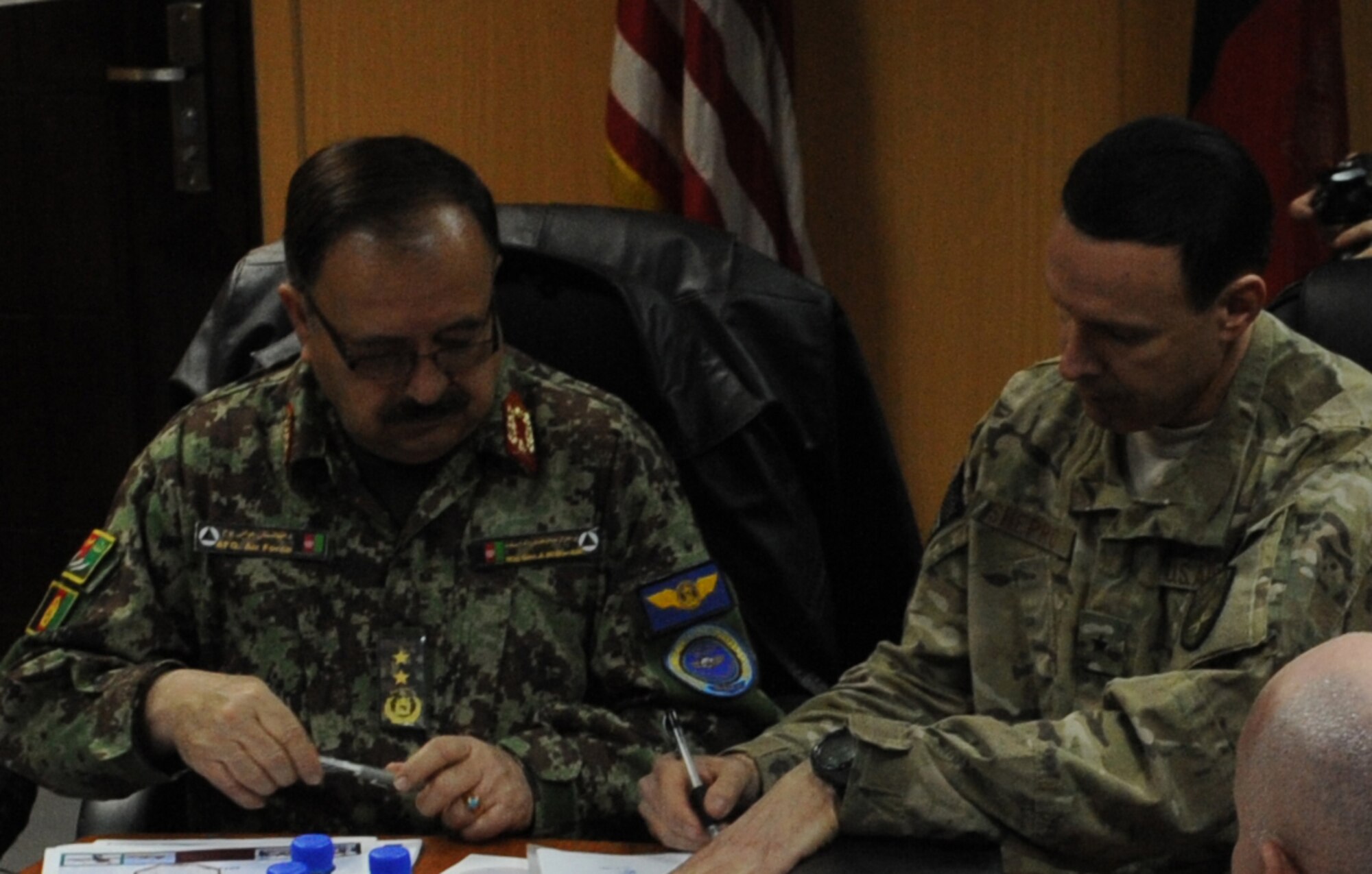 Maj. Gen. Abdul Wahab Wardak, commander of the Afghan Air Force, and Brig. Gen. Steven Shepro, commander of NATO Air Training Command-Afghanistan, sign two decrees Jan. 23, 2013 in NATC-A headquarters at the Kabul, Afghanistan, International Airport, implementing procedures to improve air response to Afghan battlefield casualties. The decrees address the high-priority missions of evacuation of wounded personnel (CASEVAC) and the dignified, culturally-appropriate transfer of fallen members of Afghan National Security Forces. (U.S. Air Force photo/Capt. Agneta Murnan)