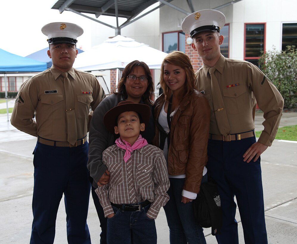 Ms. Juliana Alvarez and her nephew Diego Alvarez along with Tiffany Young pose with Lance Cpl Gabriel Nava and PFC Braydon Clendenning at Kearny High School, San Diego, CA on Jan 26. Diego was on his way to be apart of a performance at the fair event, but wanted to talk with the Marines before going on.
