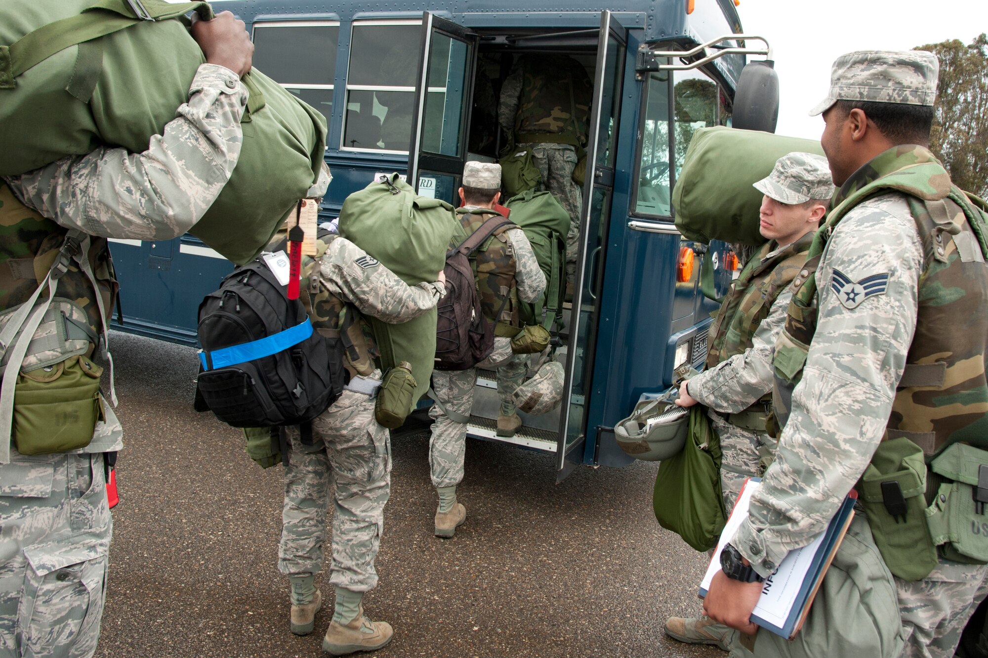VANDENBERG AIR FORCE BASE, Calif. – 30th Space Wing personnel file onto a bus headed for the Personnel Deployment Function line from the parade grounds here Friday, Jan. 25, 2013. A mobility bag consists of items essential for an Airman to have when tasked to deploy at a moments notice. (U.S. Air Force photo/Senior Airman Lael Huss)