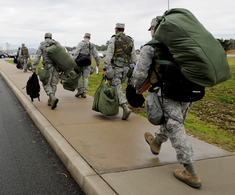VANDENBERG AIR FORCE BASE, Calif. – 30th Wing Staff Agency Airmen schlep their mobility bags to the parade ground to be bussed to the Personnel Deployment Function line here Friday, Jan. 25, 2013. A mobility bag consists of items essential for an Airman to have when tasked to deploy at a moments notice. (U.S. Air Force photo/Airman Yvonne Morales)