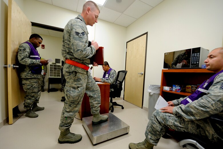 VANDENBERG AIR FORCE BASE, Calif. -- a 30th Security Force Squadron members gets weighed while processing through the Personnel Deployment Function line during an exercise here Friday, Jan. 25, 2013. The PDF line was held as part of a Consolidated Unit Inspection, a biannual inspection used to measure the base's discipline, readiness and war fighting capability through exercises, inspection and evaluations. (U.S. Air Force photo/Staff Sgt. Levi Riendeau)