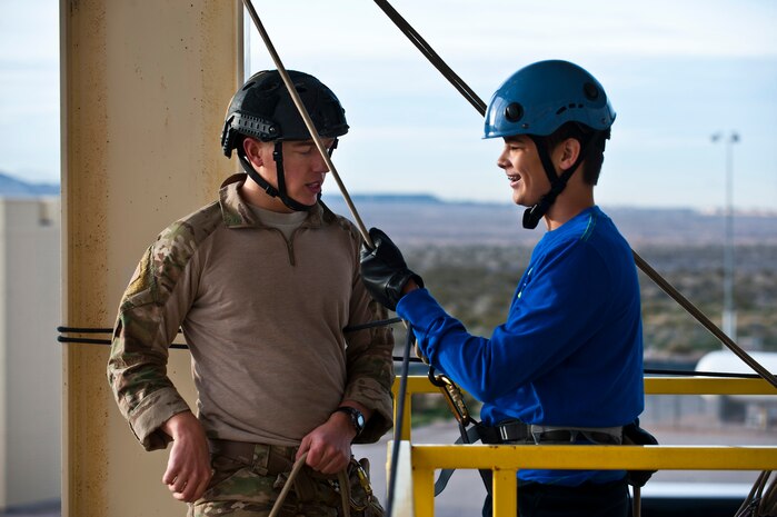 A 58th Rescue Squadron combat rescue officer provides guidance to Zachery Oberg, Junior Reserve Officer Training Corps cadet, on how to rappel Jan. 25, 2013, at Nellis Air Force Base, Nev. Throughout the year, JROTC cadets visit Nellis to experience different perspectives of the active duty military. (U.S. Air Force photo/Senior Airman Brett Clashman)