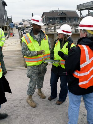 Quality Assurance Supervisor Erika Mark explains to the New York Recovery Field Office Commander Lt. Col. John A. Knight how the mobile information collection system (MICA) has created for greater efficiencies in debris site assessments, Fire Island, N.Y., Jan.11, 2013. MICA allows for information on the nature of the debris to be immediately uploaded to a central database. Debris teams, to include FEMA, will be required to conduct  inspections for each of the approximately 2,200 affected homes to complete private property debris removal assessments. (U.S. Army Photo by Sarah Gross)
