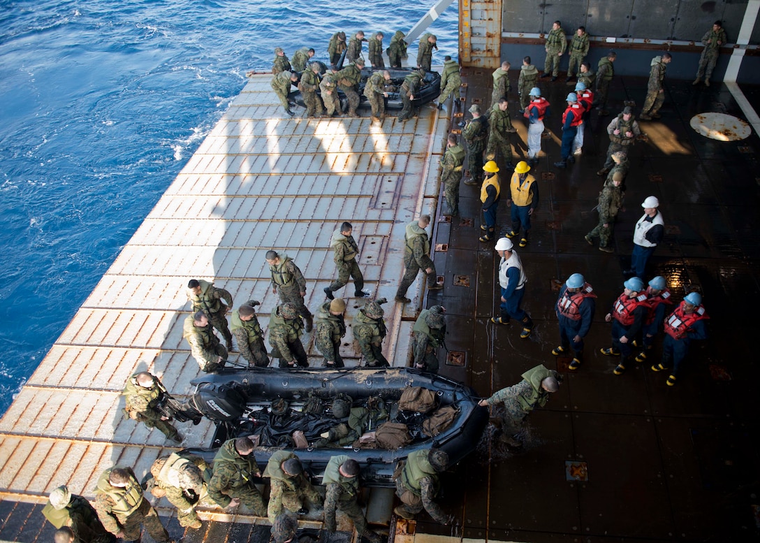 Sailors and Marines work together in the well deck of the Whidbey Island-class amphibious dock landing ship USS Tortuga (LSD 46) while recovering combat rubber raiding crafts. Tortuga is part of the Bonhomme Richard Amphibious Ready Group and is operating in the U.S. 7th Fleet area of operation.