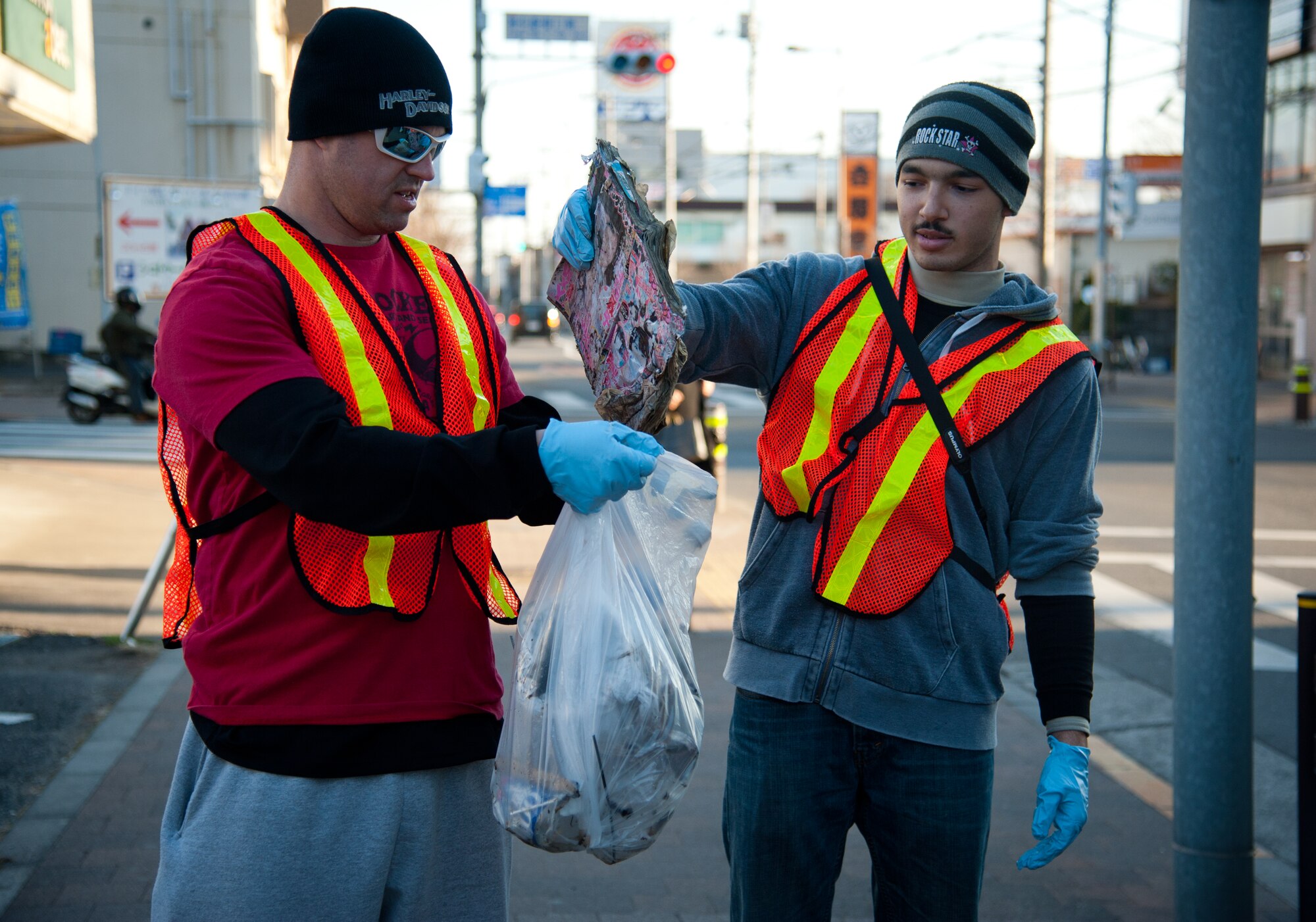 FUSSA CITY, Japan – Staff Sgt. Jeremy Hazel, 374 Civil Engineer Squadron fire protection journeyman, and Michael Aflleje, 17, throw away an a discarded magazine at Fussa City, Japan, Jan. 19, 2013.  “The event was not only an outlet to improve the local community, but it was also a great way to show the Fussa community that Yokota’s teens are good ambassadors,” Carmona said.  (U.S. Air Force photo by Airman 1st Class Soo C. Kim)