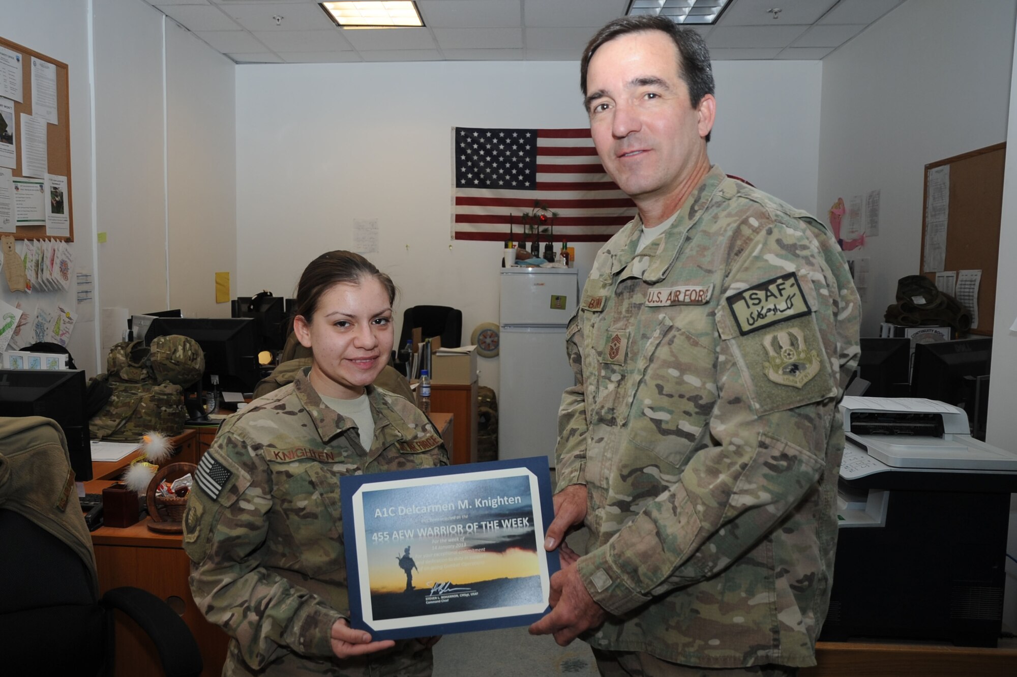 Chief Master Sgt. Steve Bohannon, Command Chief Master Sergeant of the 455th Air Expeditionary Wing, presents the "Warrior of the Week" award to Airman 1st Class Delcarmen Knighten, 455th Expeditionary Force Support Squadron sustainment technician, on Bagram Airfield, Afghanistan, Jan. 23, 2013. Knighten works with the Personnel Support for Contingency Operations team to keep accountability of Airmen assigned to the 455th AEW. (U.S. Air Force photo/Staff Sgt. David Dobrydney)