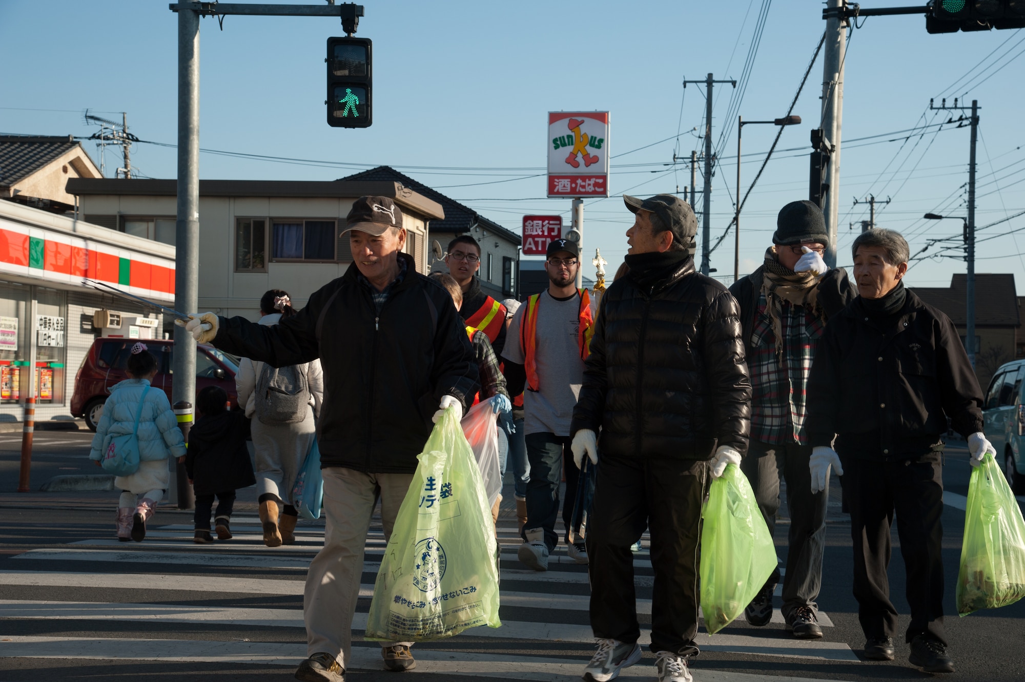 FUSSA CITY, Japan – Local volunteers and members from Yokota Air Base’s Teen Center cross the street in search of trash at Fussa City, Japan, Jan. 19, 2013.  The locals volunteered through the mayor’s office to assist during the cleanup.  (U.S. Air Force photo by Airman 1st Class Soo C. Kim)