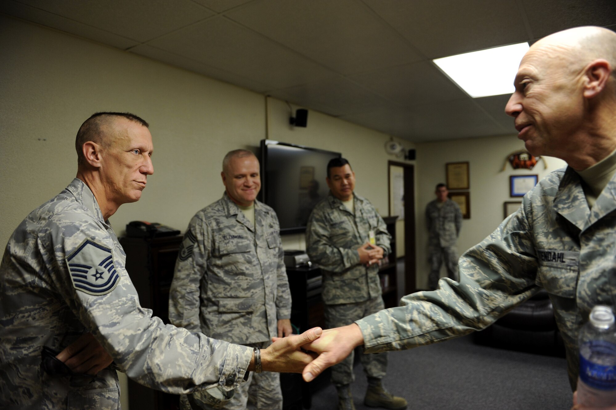U.S. Air Force Chaplain (Maj. Gen.) Howard Stendahl, Air Force Chief of Chaplains, coins Master Sgt. James Jones, 18th Civil Engineer Squadron Explosive Ordinance Disposal NCO in charge, on Kadena Air Base, Japan, Jan. 24, 2013. Stendahl was touched by Jones’ extensive deployment history with EOD. During his visit to Kadena, Stendahl joined Airmen at the Wired Bean for Ohana Night and spoke with 18th Maintenance Group personnel on the flightline. (U.S. Air Force photo/Airman 1st Class Hailey R. Davis)