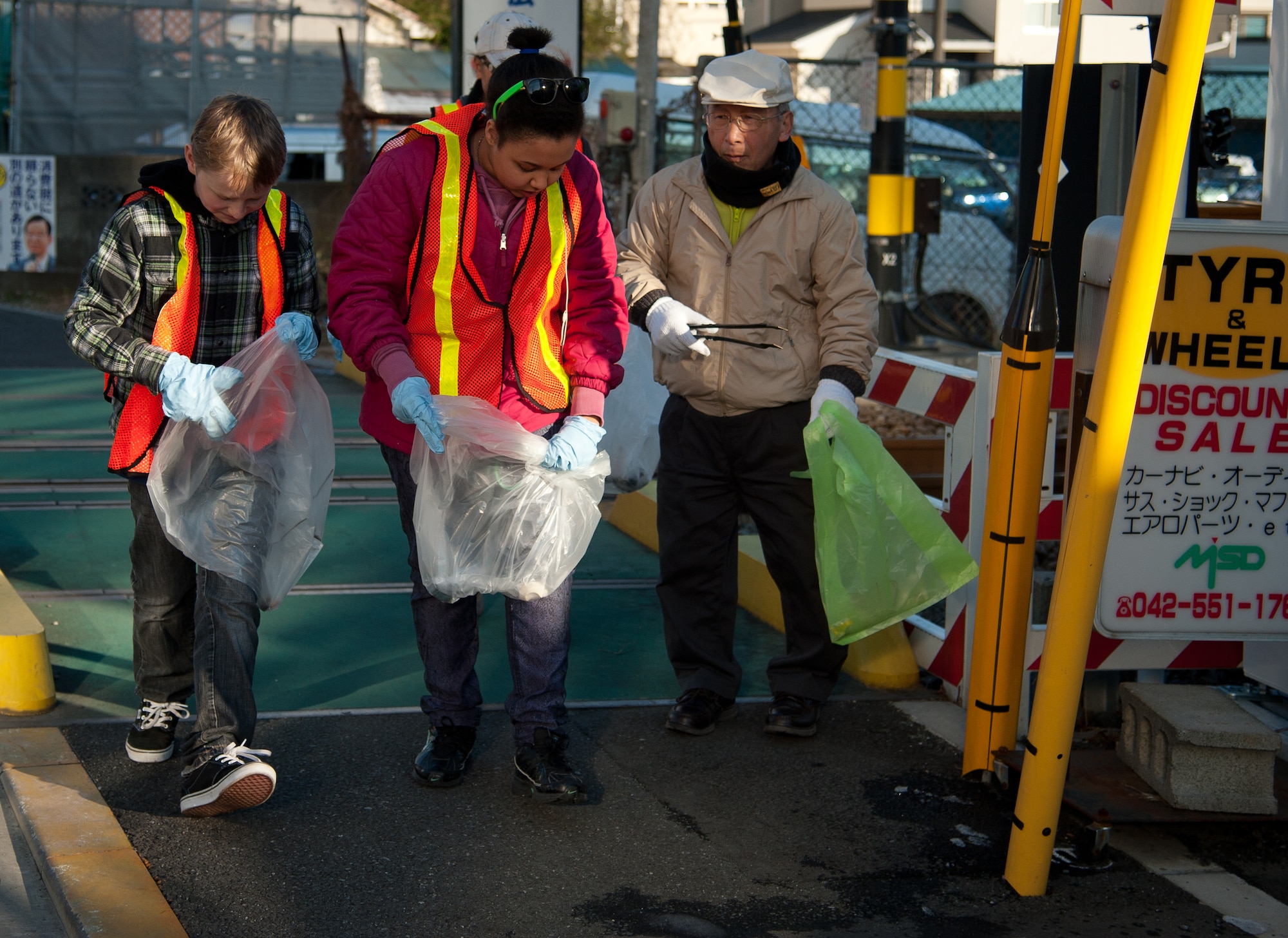 FUSSA CITY, Japan - Abram Smith, 12, and Besma Brewer, 13, from the Yokota Air Base Teen Center search for trash with a local volunteer at Fussa City, Japan, Jan. 19, 2013.  “I had fun today and I felt good about myself and for the town, “Abram Smith said.  (U.S. Air Force photo by Airman 1st Class Soo C. Kim)