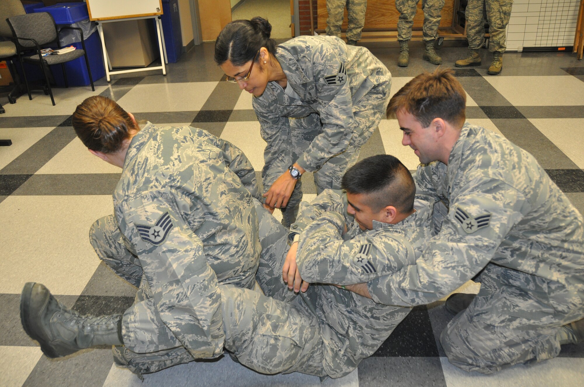 Airmen of the 514th Air Mobility Wing prepare for an upcoming readiness inspection by performing the two-person fore-and-aft carry during a self-aid and buddy care training sessions held here Jan. 27. Key players trained on core tasks in preparation for the one-day Ability to Survive and Operate inspection scheduled to be held in July (U.S. Air Force photo/Senior Airman Chelsea Smith).