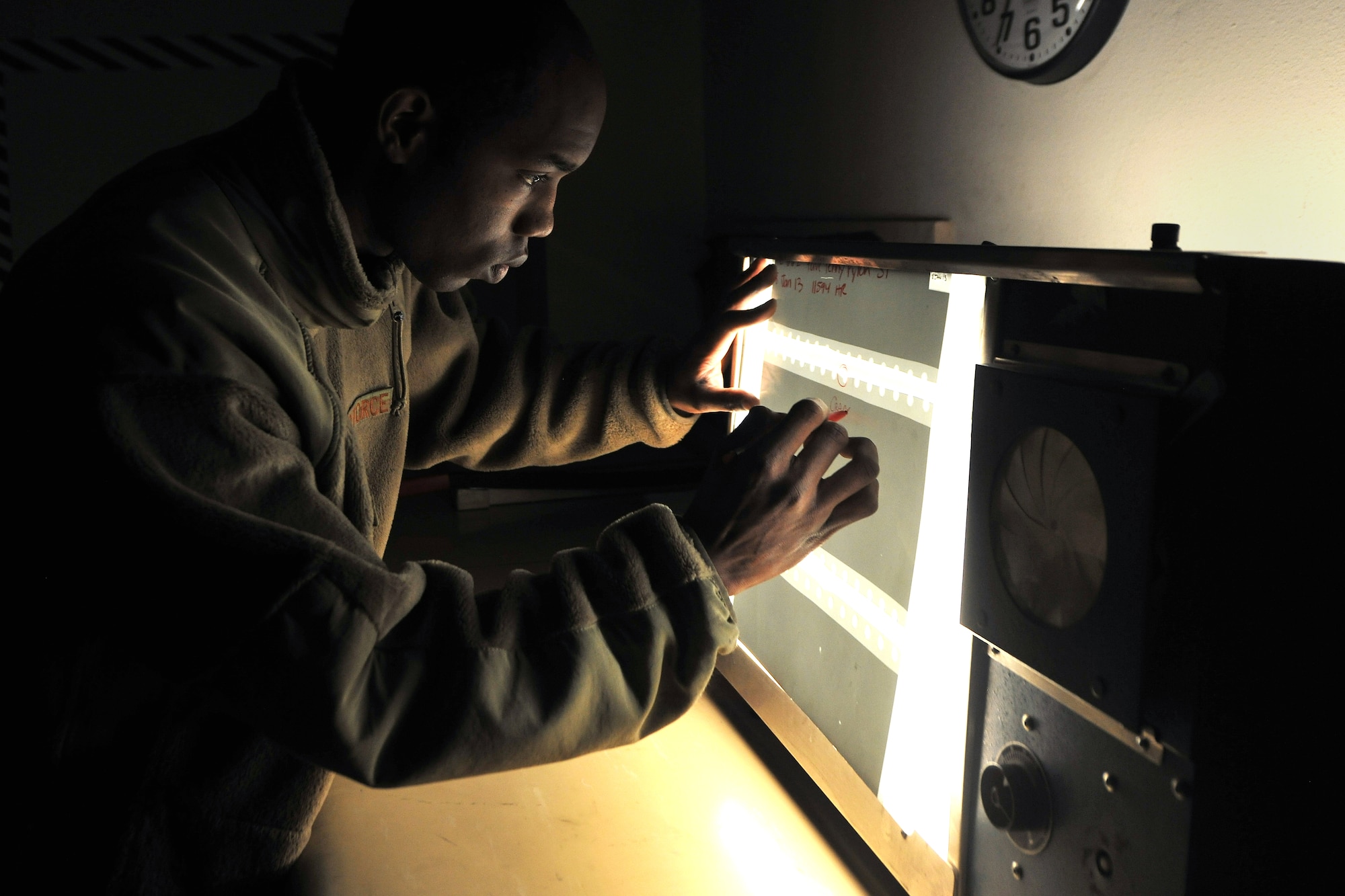 Staff Sgt. D'Shawn Jemmott, 455th Expeditionary Maintenance Squadron Non-Destructive Inspection lab NCOIC, inspects x-ray film from an A-10 pave penny pylon for cracks at Bagram Airfield, Afghanistan, Jan. 21, 2013. The x-ray film is used to see beneath the surface of aircraft parts to find any cracks or defects.  (U.S. Air Force photo/Senior Airman Chris Willis)