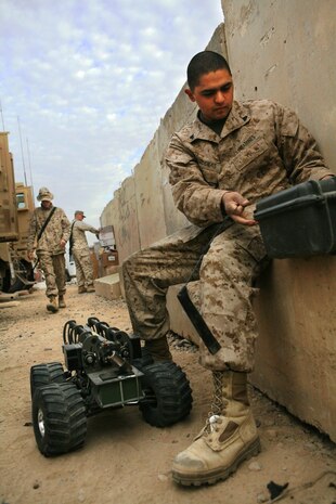 Cpl. Raul Cardenas, 24, from Santa Ana, Calif., vehicle commander for 2nd Squad, Security Company, Combat Logistics Battalion 5, 1st Marine Logistics Group, prepares a Multi-function Agile Remote Control Robot prior to a mission Dec. 20. Security Co. uses the MARCbot to safely investigate possible Improvised Explosive Devices. Security Co. ensures that convoys reach their destination safely by providing security throughout the trip.