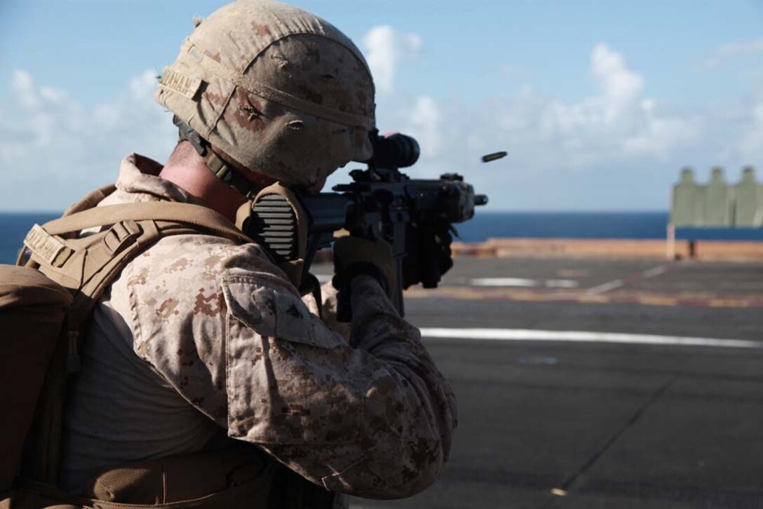 Lance Cpl. Ryan S. Callahan, automatic gunner, 3rd Platoon, Kilo Company, Battalion Landing Team 3/5, 15th Marine Expeditionary Unit, fires his Infantry Automatic Rifle at targets on the flight deck of the USS Peleliu, Jan. 22. Kilo Company is one of three rifle companies in BLT 3/5, the 15th MEU's ground combat element. The 15th MEU is deployed as part of the Peleliu Amphibious Ready Group as a U.S. Central Command theater reserve force, providing support for maritime security operations and theater security cooperation efforts in the U.S. 5th Fleet area of responsibility. Callahan, 24, is from Bluffton, S.C. (U.S. Marine Corps photo by Cpl. John Robbart III)