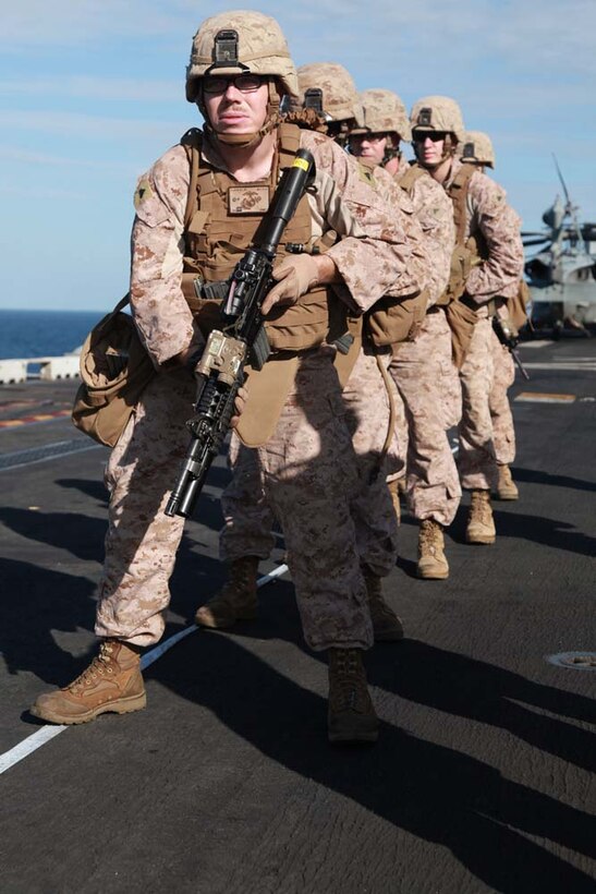 Marines with Kilo Company, Battalion Landing Team 3/5, 15th Marine Expeditionary Unit, prepare to engage their targets on the flight deck of the USS Peleliu, Jan. 22. Kilo Company is one of three rifle companies in BLT 3/5, the 15th MEU's ground combat element. The 15th MEU is deployed as part of the Peleliu Amphibious Ready Group as a U.S. Central Command theater reserve force, providing support for maritime security operations and theater security cooperation efforts in the U.S. 5th Fleet area of responsibility. (U.S. Marine Corps photo by Cpl. John Robbart III)