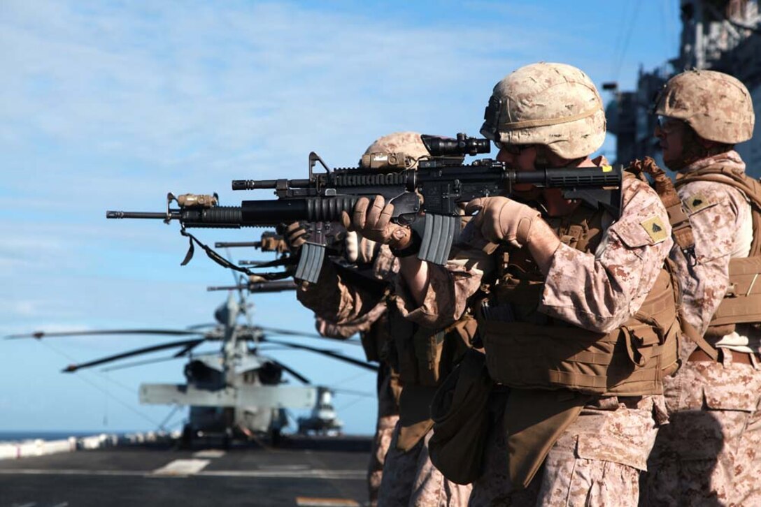 Marines with Kilo Company, Battalion Landing Team 3/5, 15th Marine Expeditionary Unit, fire at their targets on the flight deck of the USS Peleliu, Jan. 22. Kilo Company is one of three rifle companies in BLT 3/5, the 15th MEU's ground combat element. The 15th MEU is deployed as part of the Peleliu Amphibious Ready Group as a U.S. Central Command theater reserve force, providing support for maritime security operations and theater security cooperation efforts in the U.S. 5th Fleet area of responsibility. (U.S. Marine Corps photo by Cpl. John Robbart III)