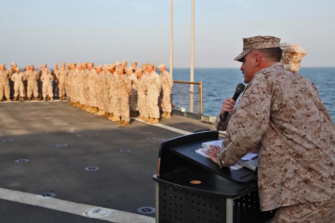 Lieutenant Col. John Wiener, commanding officer, Combat Logistics Battalion 15, 15th Marine Expeditionary Unit, speaks to his Marines and sailors after presenting the Bronze Star with Combat Distinguishing Device to 1st Sgt. Bradley G. Simmons, Sergeant Major, CLB-15, 15th MEU, during his award ceremony aboard the USS Rushmore, Jan. 25. Simmons, 34, is a native of Liberal, KS. The 15th MEU is deployed as part of the Peleliu Amphibious Ready Group as a U.S. Central Command theater reserve force, providing support for maritime security operations and theater security cooperation efforts in the U.S. 5th Fleet area of responsibility. (U.S. Marine Corps photo by Cpl. Timothy R. Childers)