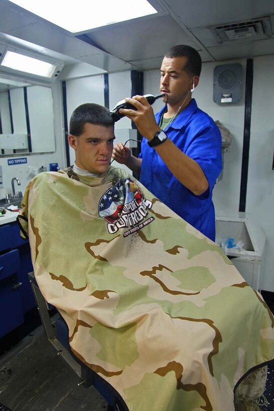 Sergeant Jordan Kelly, chief, Fire Control Team 32, Air Naval Gunfire Liaison Company, Command Element, 15th Marine Expeditionary Unit, gives a haircut to Lance Cpl. James Hasting, a forward observer in the same team, aboard the USS Rushmore, Jan. 22. The 15th MEU is deployed as part of the Peleliu Amphibious Ready Group as a U.S. Central Command theater reserve force, providing support for maritime security operations and theater security cooperation efforts in the U.S. 5th Fleet area of responsibility. Kelly, 25, is from Mexico, Mo., and Hasting, 23, is from Troy, Mo. (U.S. Marine Corps photo by Cpl. Timothy R. Childers)
