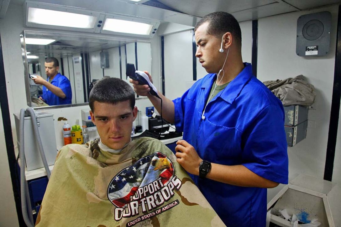 Sergeant Jordan Kelly, chief, Fire Control Team 32, Air Naval Gunfire Liaison Company, Command Element, 15th Marine Expeditionary Unit, gives a haircut to Lance Cpl. James Hasting, a forward observer in the same team, aboard the USS Rushmore, Jan. 22. The 15th MEU is deployed as part of the Peleliu Amphibious Ready Group as a U.S. Central Command theater reserve force, providing support for maritime security operations and theater security cooperation efforts in the U.S. 5th Fleet area of responsibility. Kelly, 25, is from Mexico, Mo., and Hasting, 23, is from Troy, Mo. (U.S. Marine Corps photo by Cpl. Timothy R. Childers)