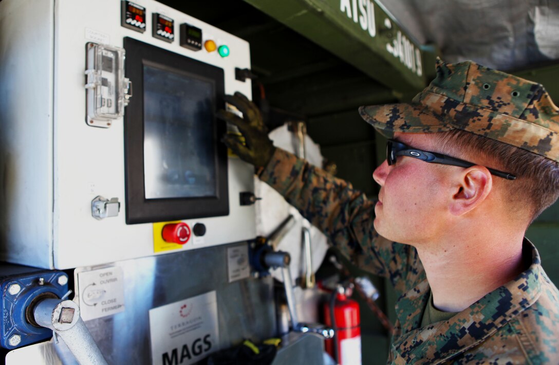 Pvt. Dylan Bolt, a mortarman with 3rd Battalion, 3rd Marine Regiment, 3rd Marine Division, operates the tablet-like interface on the MAGS (Micro Auto Gasification System) here Jan 25, as part of Exercise Lava Viper. MAGS is being tested by the U.S. Marine Corps Forces Pacific Experimentation Center to determine whether it is a viable waste management solution for Marines operating out of austere environments. The machine is capable of handling the daily waste disposal needs of approximately 1,000 troops, converting 95 percent of the waste to gas, which is then used to fuel the process. Bolt, 21, is from Prosser, Wash.