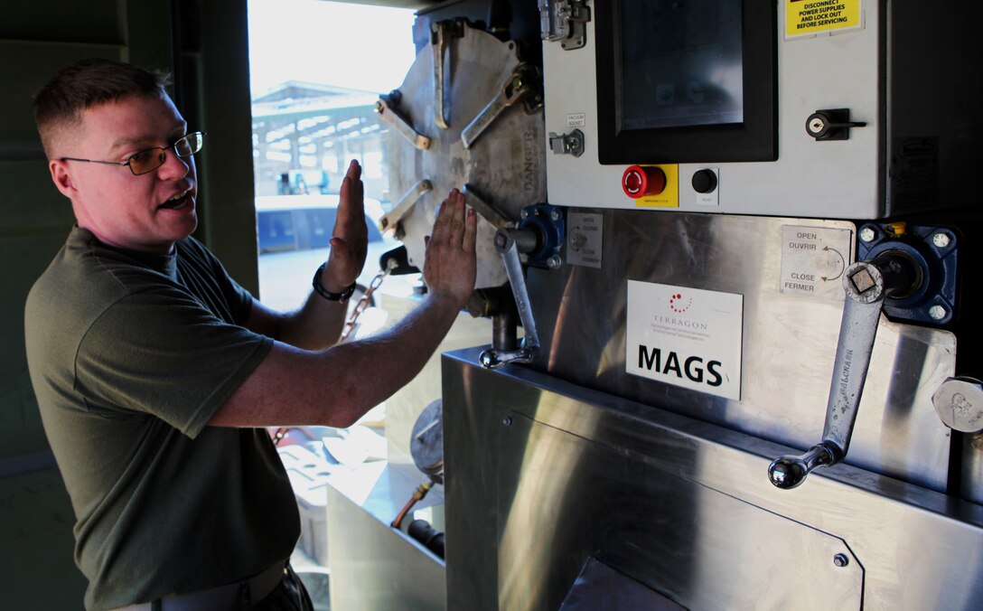 Lance Cpl. James Russell, an electrician with Combat Logistics Battalion 3, 3rd Marine Logistics Group, explains how he and other Marines operate MAGS (Micro Auto Gasification System) here Jan 25. The system was being tested as a waste disposal solution during Lava Viper, a Marine Corps field training exercise that takes place at PTA, and is being considered for additional follow-on tests in austere environments. In a controlled extreme-heat environment, Processing about 50 pounds of solid waste per hour, MAGS is capable of handling the daily waste disposal needs of approximately 1,000 troops, converting 95 percent of the waste to gas, which is then used to fuel the process. Russell, 24, is from Poughkeepsie, N.Y.  