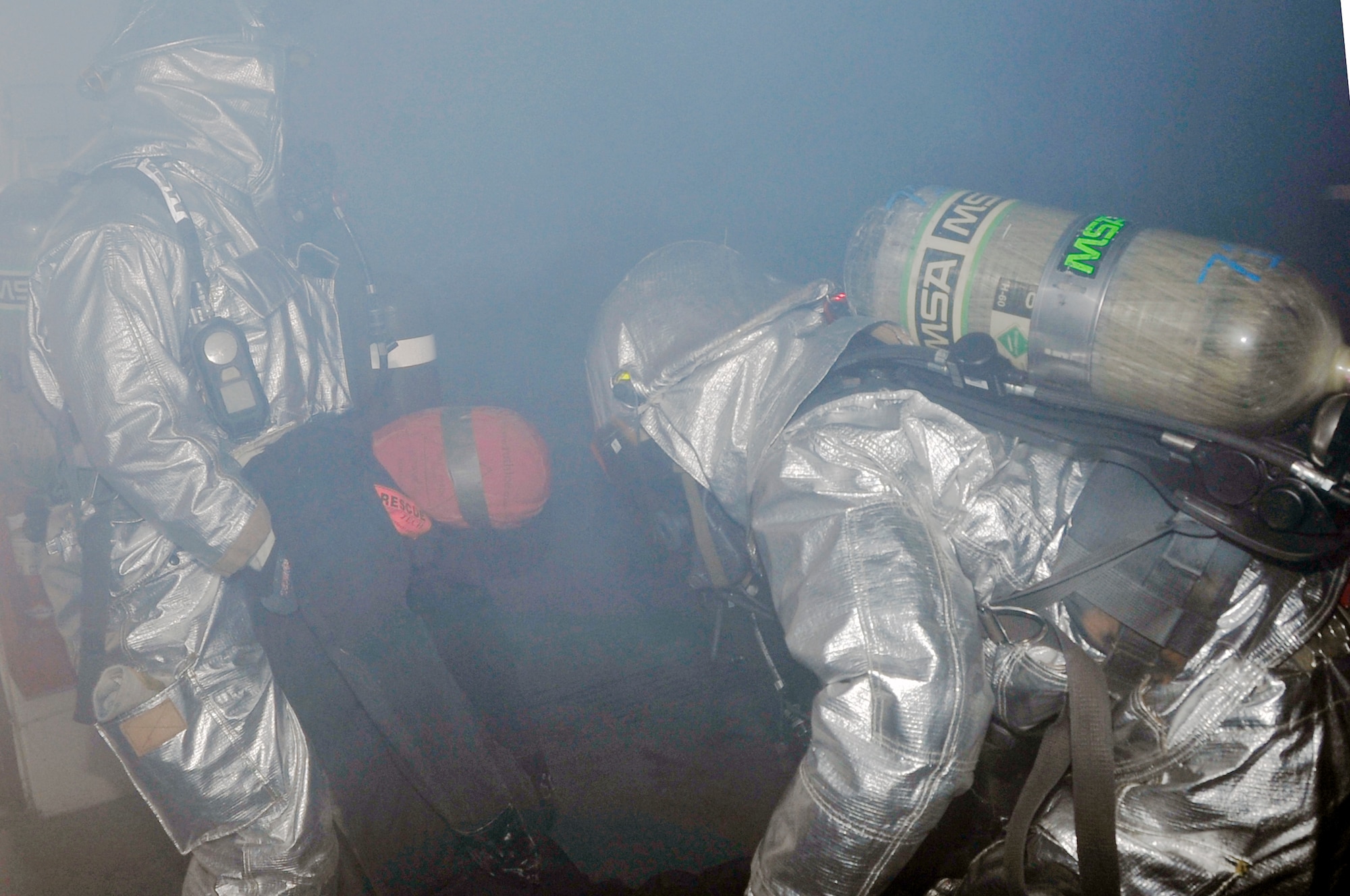 Staff Sgt. Terrell Thomas, left, and Staff Sgt. Travis Barrett, 51st Civil Engineer Squadron fire services lead firefighters, relocate a simulated injured person out of a burning building during a fire training exercise at Osan Air Base, Republic of Korea, Jan. 24, 2012. The exercise was held at the 51st Munitions Squadron compound. (U.S. Air Force photo/Airman 1st Class Alexis Siekert)