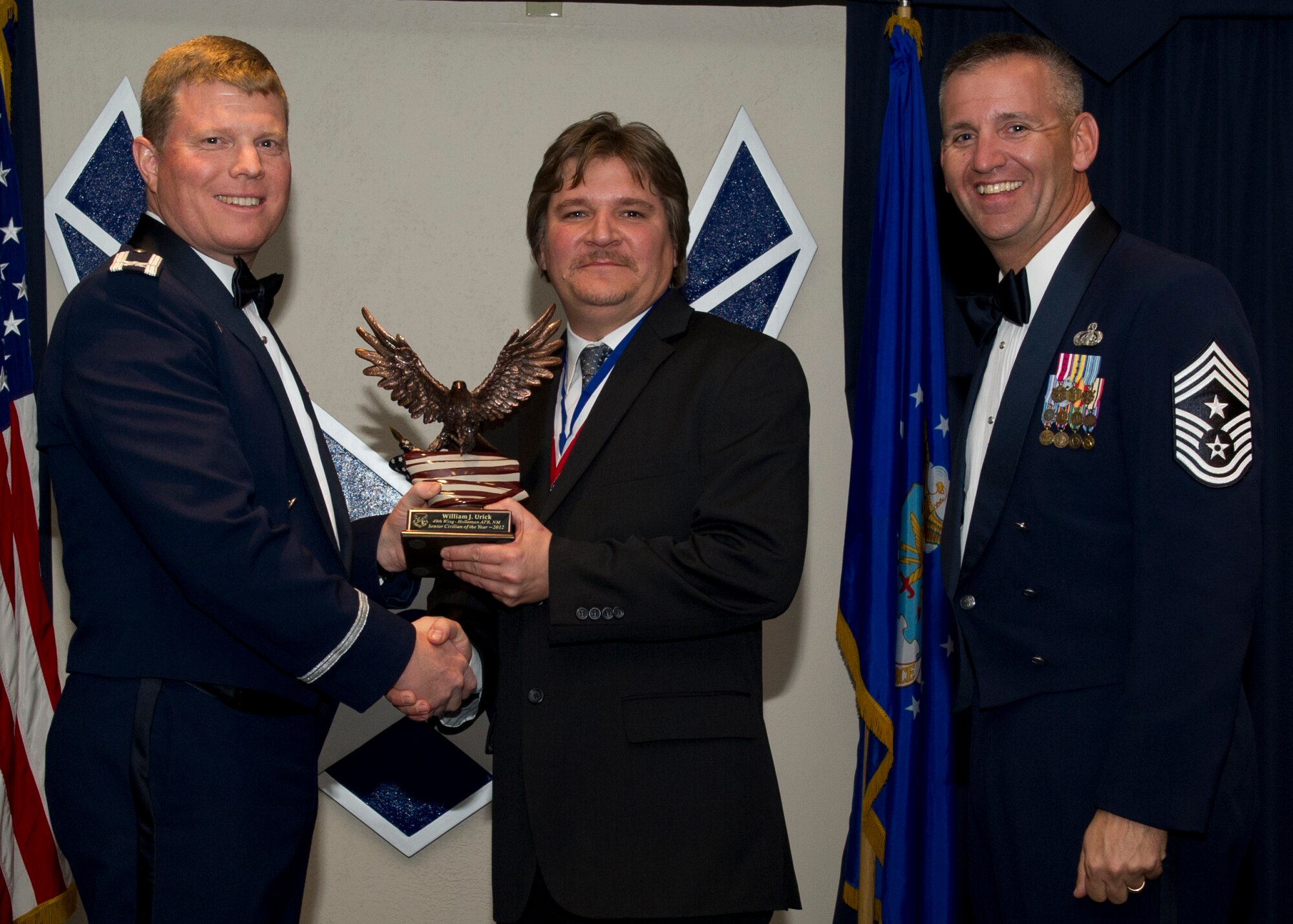 Colonel Andy Croft, 49th Wing commander, presents the 49th WG’s 2012 Senior Civilian of the Year Award to William Urick, 49th Operations Group, at the Annual Awards Banquet Jan. 25 at the Holloman Air Force Base, N.M., Enlisted Club. The other nominees for the award were Virginia McKinley, 49th Mission Support Group, Emil Brupbacher, 49th Wing Staff, and Shannan Bergtholdt, 49th Medical Group. (U.S. Air Force photo by Senior Airman Siuta B. Ika/ Released)
