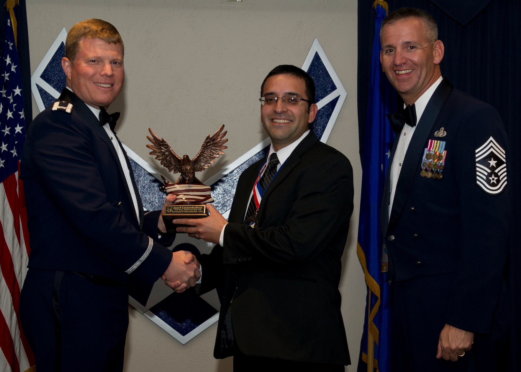 Colonel Andy Croft, 49th Wing commander, presents the 49th WG’s 2012 Intermediate Civilian of the Year Award to Juan Lavarreda Perez, 49th Operations Group, at the Annual Awards Banquet Jan. 25 at the Holloman Air Force Base, N.M., Enlisted Club. The other nominees for the award were Maria Rodriguez-Acevedo, 49th Maintenance Group, Gary Moravec, 49th Mission Support Group, Diane Adams, 49th Wing Staff, and David Wertz, 49th Medical Group. (U.S. Air Force photo by Senior Airman Siuta B. Ika/ Released)