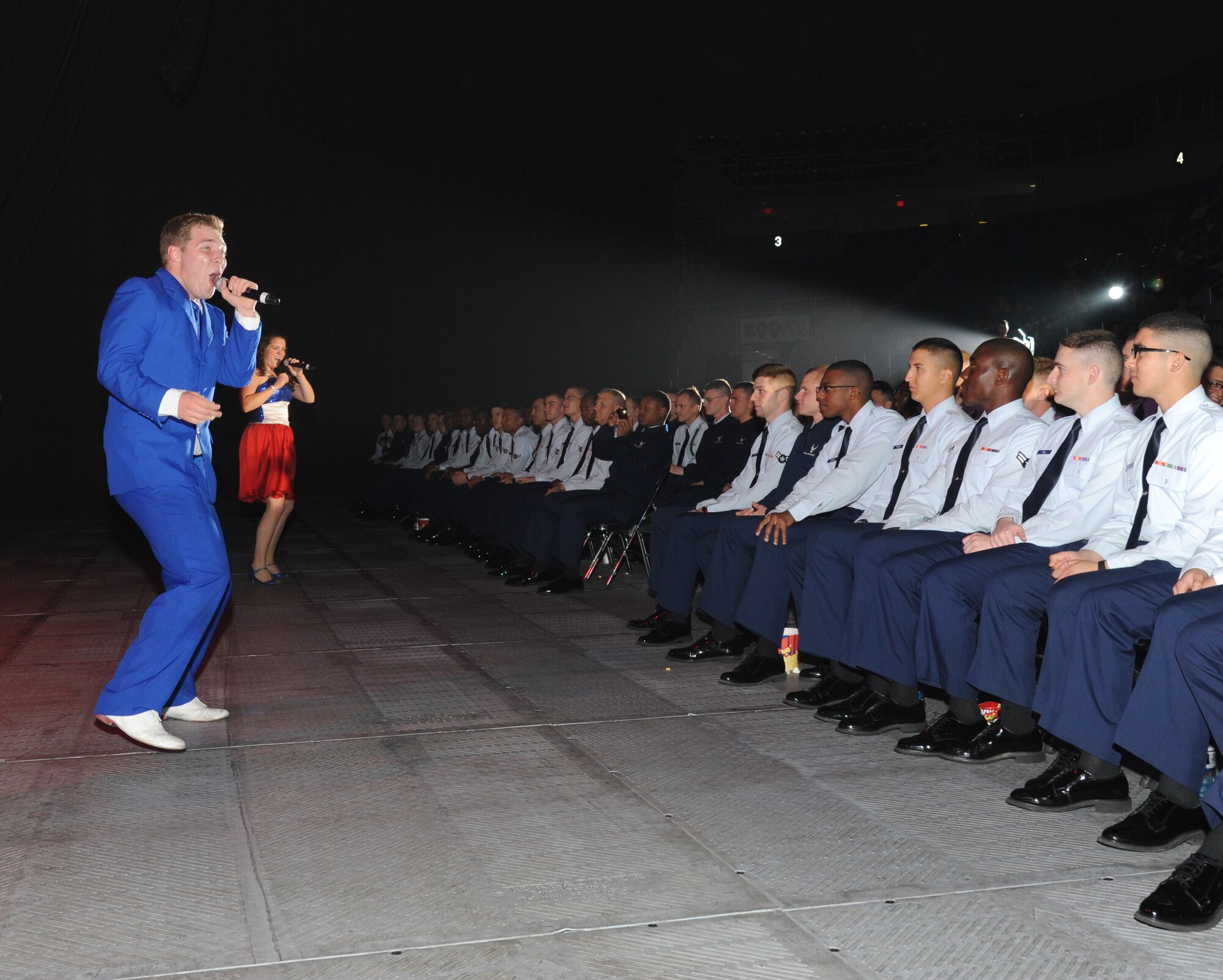 Senior Airman Timothy Sentz, Scott Air Force Base, Ill., and Capt. Ashley Elmore, Ellsworth AFB, S.D., get closer to the Airmen from Keesler Air Force Base, Miss., as they perform during the Tops in Blue 2012 World Tour Jan. 27, 2013, at the Mississippi Coast Coliseum.  Hundreds of Keesler Airmen, families and community members watched and listened as the sequin-studded members of Tops in Blue performed their diverse show.  (U.S. Air Force photo by Kemberly Groue)