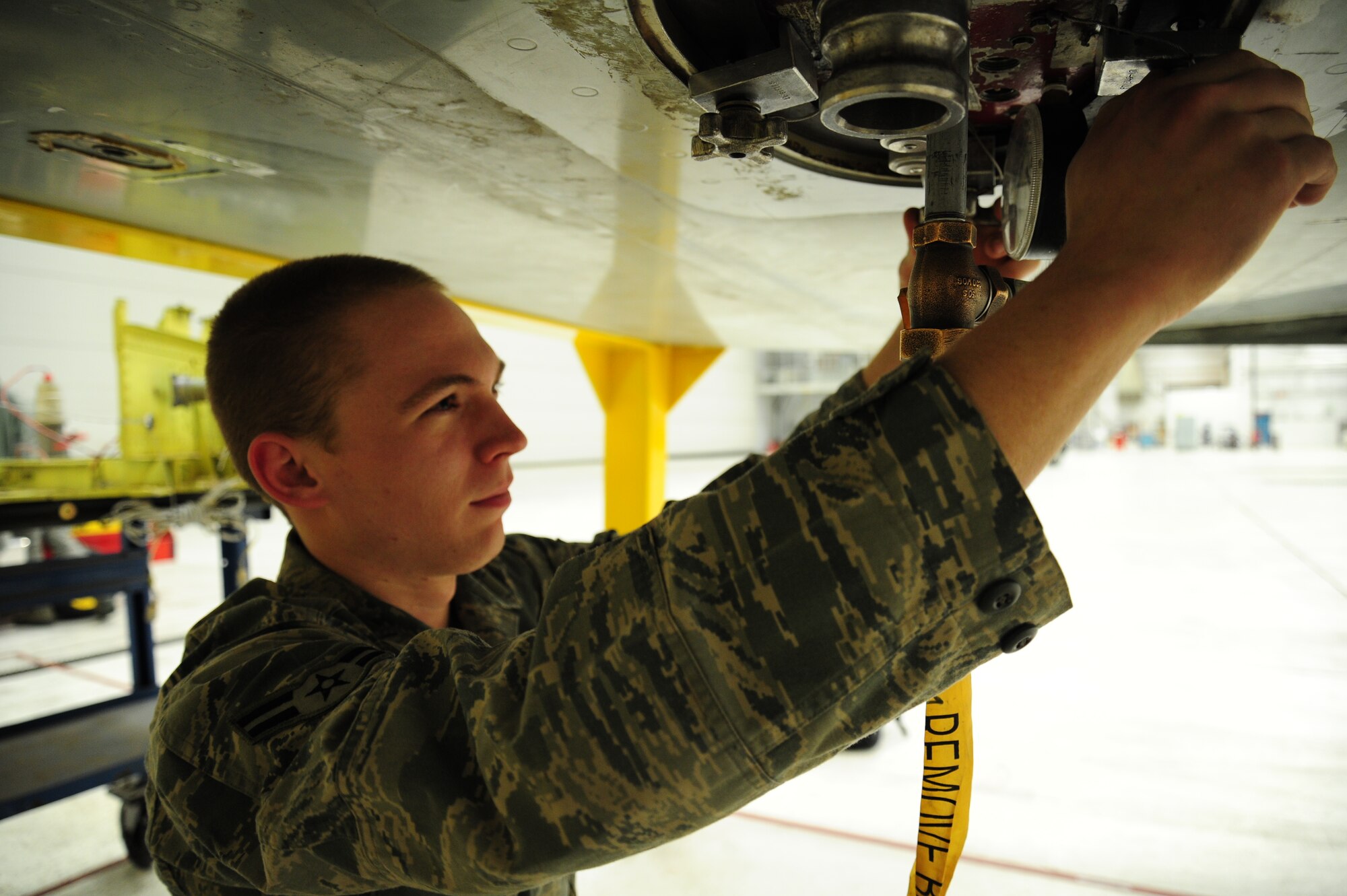 Airman 1st Class Randall Lewallen, 92nd Aircraft Maintenance Squadron fuel systems apprentice, installs a pressure door on a KC-135 Stratotanker at Fairchild Air Force Base, Wash., Jan. 28, 2013. Installing a pressure door helps find the exit point of any fuel leaks to the aircraft. (U.S. Air Force photo by Airman 1st Class Janelle Patiño)