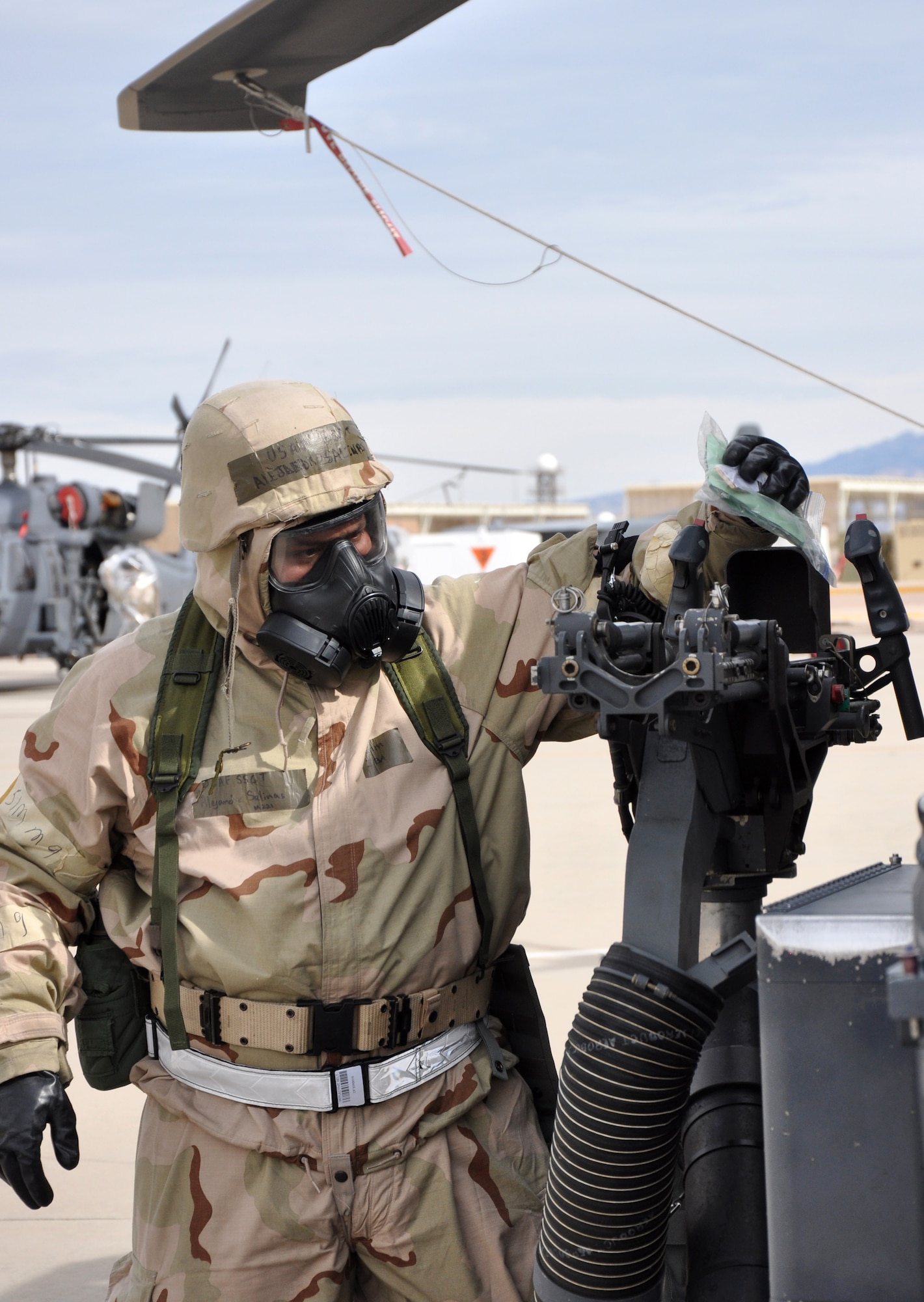 A crew chief from the 943rd Maintenance Squadron simulates decontaminating an HH-60 Pave Hawk helicopter during a Chemical, Biological, Radiological, Nuclear and Explosive defensive training exercise on the flight line at Davis Monthan Air Force Base, Ariz. prior to a simulated combat rescue sortie. Airmen from the 943rd Rescue Group worked on honing their CBRNE skills in preparation for the upcoming Operational Readiness Exercise with the 920th Rescue Wing in February.  (U.S. Air Force Photo/ Master Sgt. Luke Johnson)