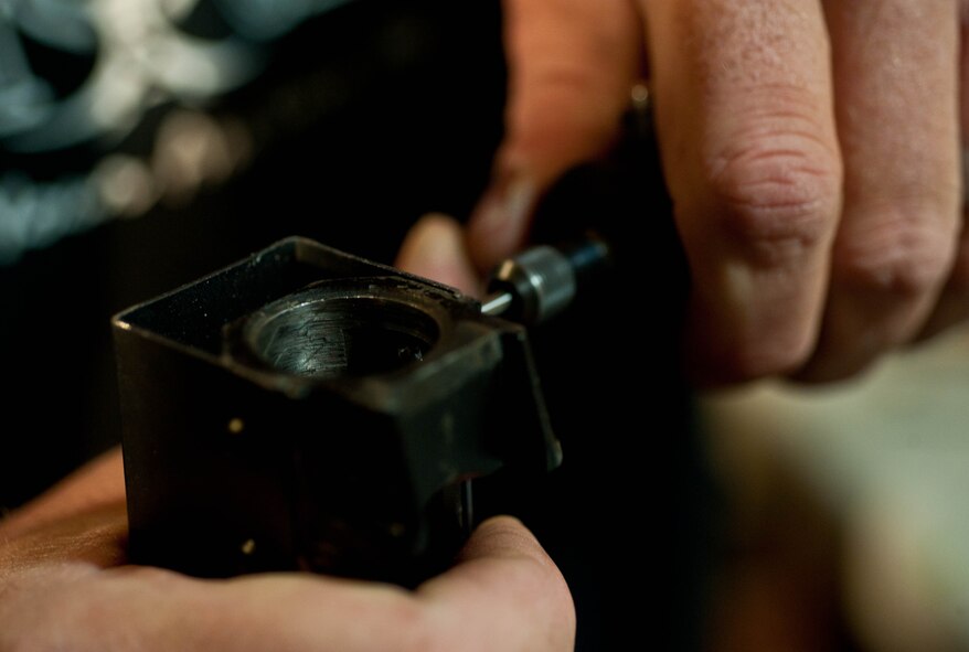 Master Sgt. Monte Ealy, 28th Civil Engineer readiness and emergency management NCO in charge, tightens the frame of an AK- pattern semi-automatic rifle replica in Rapid City, S.D., Dec. 11, 2012. Ealy built his first AK-pattern Yugoslavian rifle, with a folding stock in 2005. Since then he has built, rebuilt or modified 24 rifles, four pistols, and a shotgun. (U.S. Air Force photo by Airman 1st Class Zachary Hada/Released)