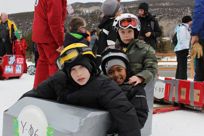 Maj. Frankie Robinson and Maj. Charles Michaels' children prepare to brave Discovery slope at Keystone Resort during SnoFest's cardboard derby. The sled, built by the 50th Space Wing Program Management Directorate office, earned the title "The Silver Bullet" because of its duct tape exterior. (U.S. Air Force photo/1st Lt. Stacy Glaus).