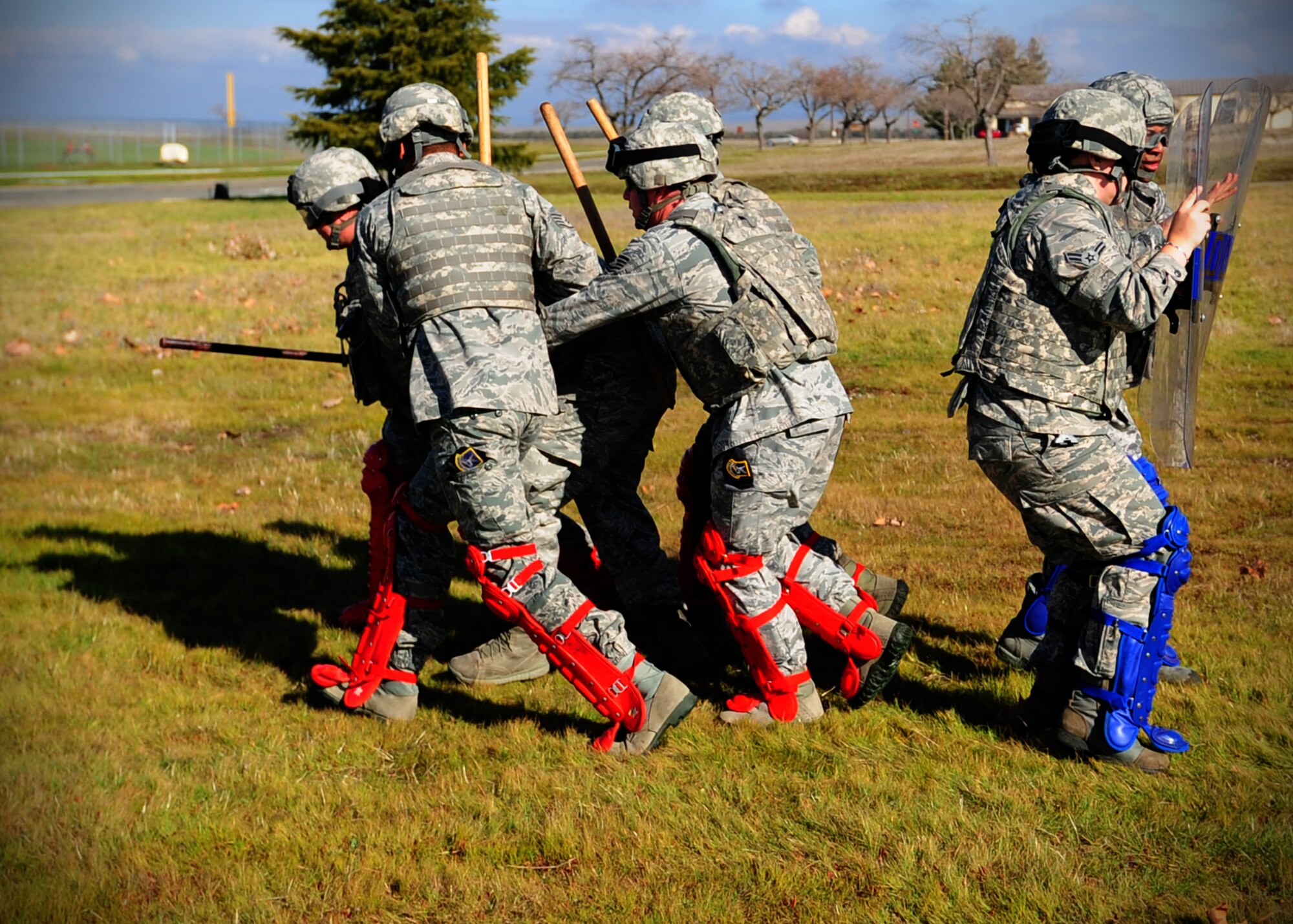 9th Security Forces Squadron patrolmen escourt a mock citizen back to safety during a simulated protest at Beale Air Force Base, Calif., Jan. 25, 2013. Patrolmen use riot shields, impact weapons and personal protective equipment to shield themselves from attacks. (U.S. Air Force photo by Senior Airman Shawn Nickel/Released)