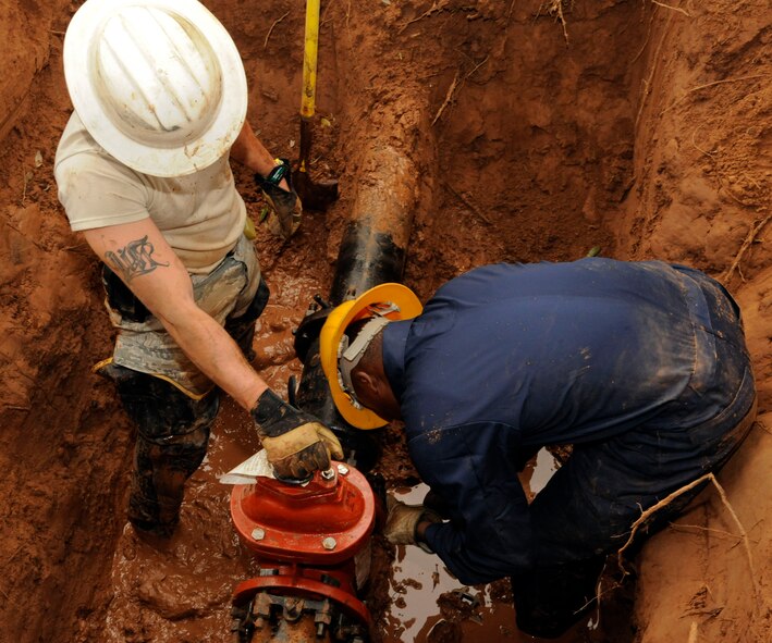 Senior Airman Cody Meador and Airman 1st Class Kevin Yator, 2nd Civil Engineer Squadron utilities journeymen, conduct repairs on a damaged pipe on Barksdale Air Force Base, La., Jan. 25. A new valve was installed on the pipe to stop the leak which prevented the purchase of a new pipe, saving the Air Force money in the process. The 2 CES has the responsibility of maintaining base infrastructure and setting up construction projects.  (U.S. Air Force photo/Airman 1st Class Andrew Moua)