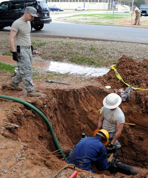 Staff Sgt. Thomas Zweydoff, 2nd Civil Engineer Squadron utilities craftsman, observes as Senior Airman Cody Meador and Airman 1st Class Kevin Yator, 2 CES, tighten bolts on a water valve on Barksdale Air Force Base, La., Jan. 25. The water valve was put in place to fix a leaking pipe. The 2 CES is responsible for maintaining base infrastructure and setting up construction projects. (U.S. Air Force photo/Airman 1st Class Andrew Moua)