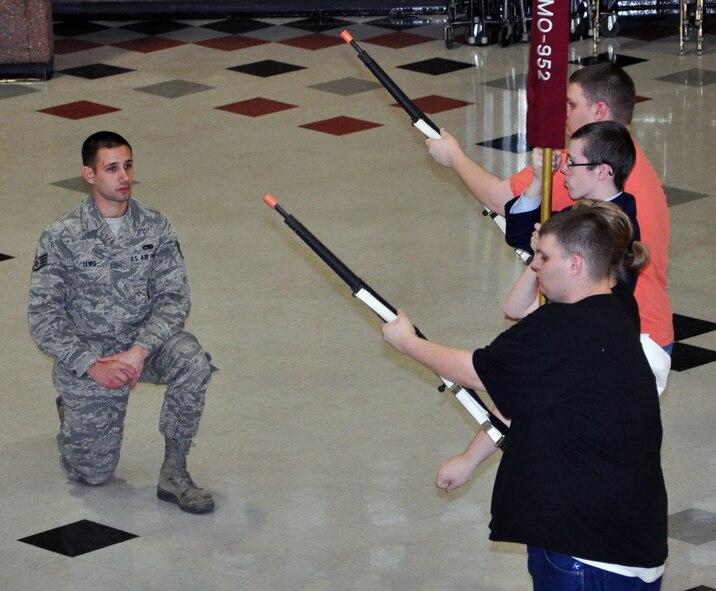 Staff Sgt. Travis Lewis, 509th Bomb Wing Honor Guard assistant noncommisssioned officer in charge, observes students of the Lee's Summit North High School Air Force Junior Reserve Officers' Training Corps present colors on Jan. 24, 2013. Lewis travels there several times a week to help train the school's AFJROTC program in drill and ceremony. Lewis is a traditional reservist with the 442nd Aircraft Maintenance Squadron, which is part of the 442nd Fighter Wing, an A-10 Thunderbolt II Air Force Reserve unit at Whiteman Air Force Base, Mo. (U.S. Air Force photo by Senior Airman Wesley Wright/released)