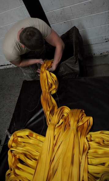 Airman 1st Class Tyler Shepherd, 2nd Operations Support Squadron Aircrew Flight Equipment parachute shop, packs a drag parachute on Barksdale Air Force Base, La., Jan. 25. The drag chute is 185 pounds and is used to slow down an aircraft after landing. (U.S. Air Force photo/Airman 1st Class Benjamin Gonsier)