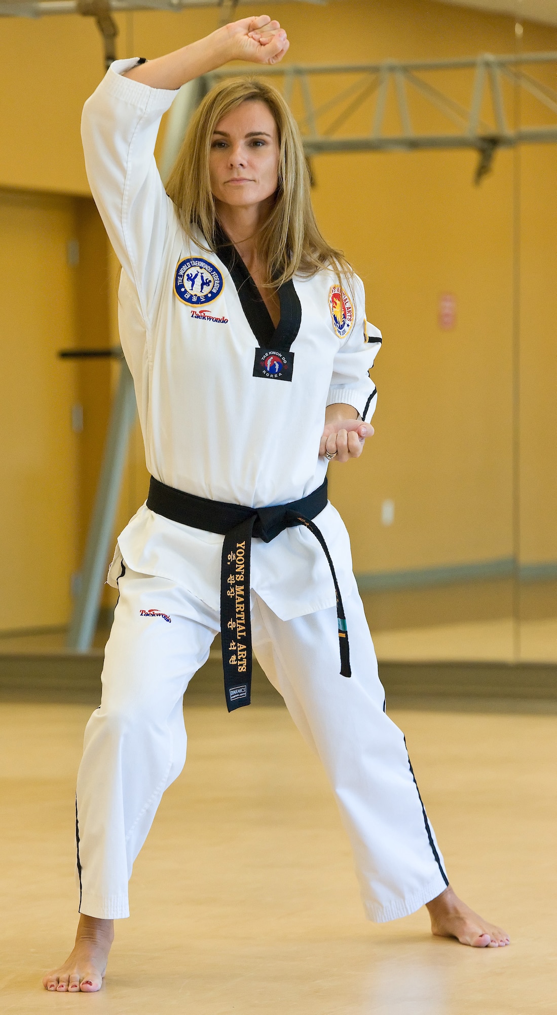 Dawn Fiore, the wife a Reserve pilot assigned to the 326th Airlift Squadron, Dover Air Base, Del., demonstrates a high block while practicing forms Nov. 16, 2012, at the base fitness center. Fiore was diagnosed with multiple sclerosis in 2005 but has since earned a first degree black belt in Taekwondo. (U.S. Air Force photo/Roland Balik)