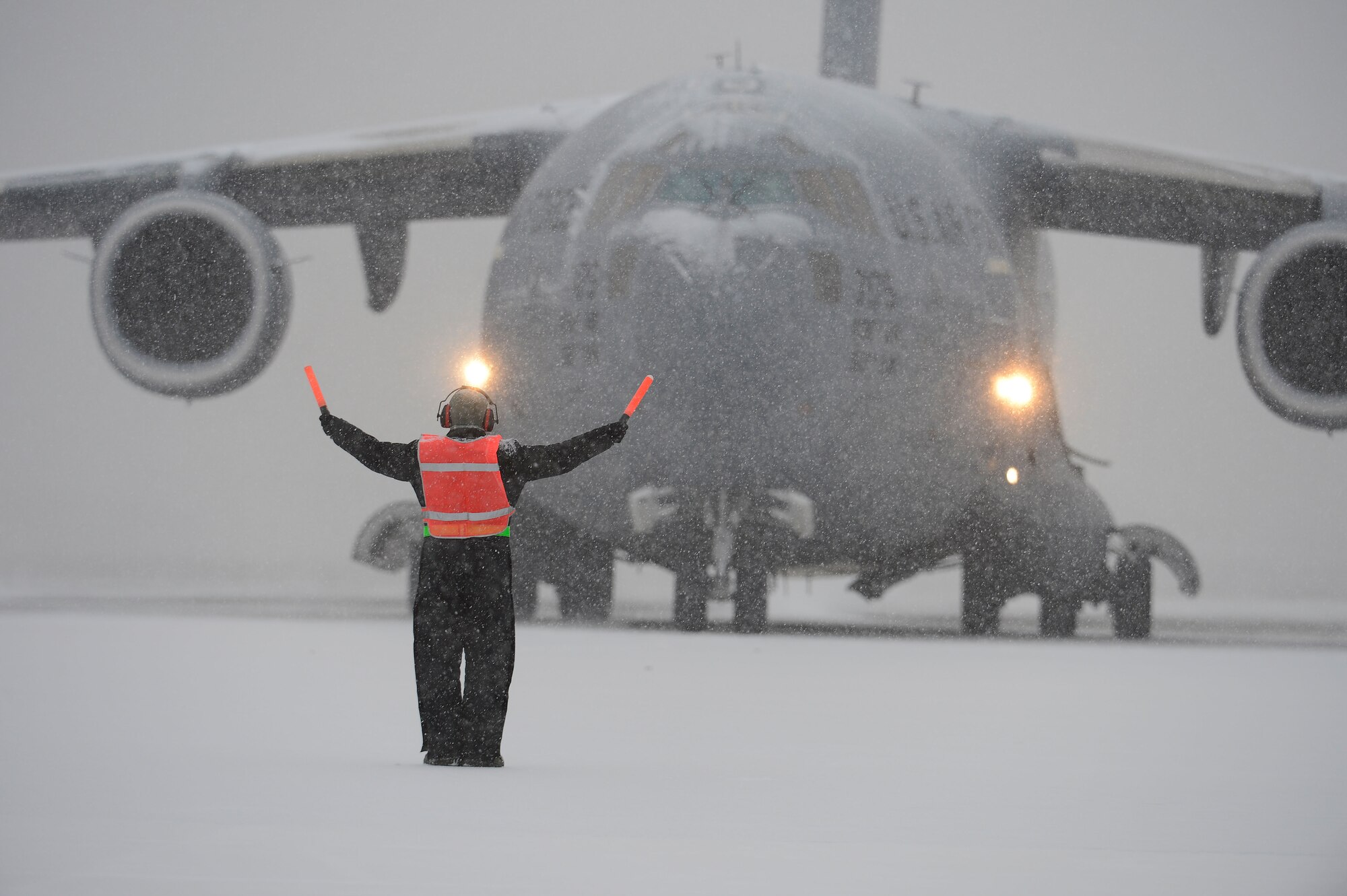 Airman 1st Class Caleb Mason, 736th Aircraft Maintenance Squadron marshals a C-17A Globemaster III from the 436th Airlift Wing at Dover Air Force Base, Del. during a snowstorm, Jan. 25, 2013. USAF photo/Greg L. Davis