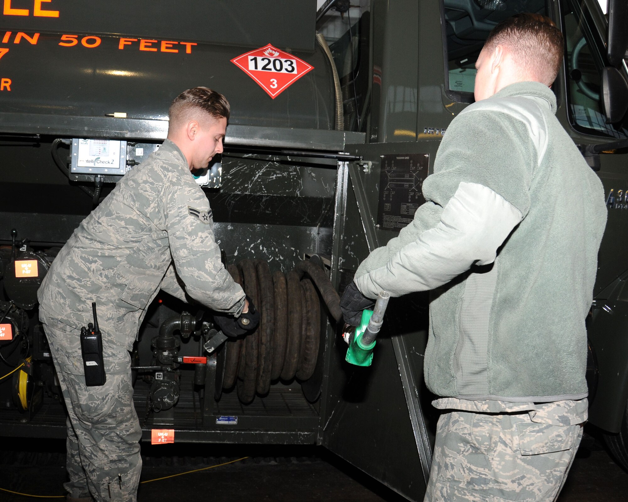 Airman 1st Class Christopher Florczyk, 100th Logistics Readiness Squadron refueling maintenance technician from Poolesville, Md., left, and Staff Sgt. Jonathan Spell, 100th LRS refueling maintenance NCO-in-charge from Charleston, S.C., reels in a hose during a check Jan. 25, 2013, at RAF Mildenhall, England. The 100th LRS fuels flight performs daily checks to keep equipment in-commision, keeping mission rate above 96 percent; above the United States Air Force in Europe standards. (U.S. Air Force photo by Gina Randall/Released)