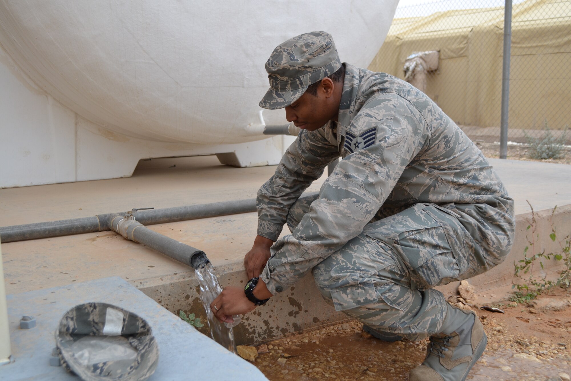 SOUTHWEST ASIA - Staff Sgt. DeSean Jones gathers a water sample to test for purity. Jones is assigned to the 64th Expeditionary Support Squadron. (U.S. Air Force photo/Staff Sgt. Cynthia Brockes)