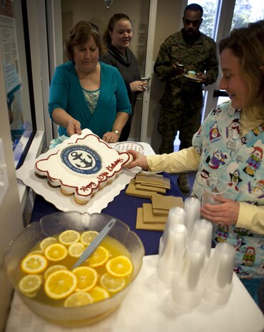 Members of Navy Marine Corps Relief Society break frosting in celebration of NMCRS’s 109th birthday aboard Marine Corps Base Camp Lejeune Jan. 23. Founded in 1904, NMCRS staff originally consisted of only 19 volunteers. The first NMCRS office was started with a portion of the $9,000 proceeds collected from a football game between Army and Navy.