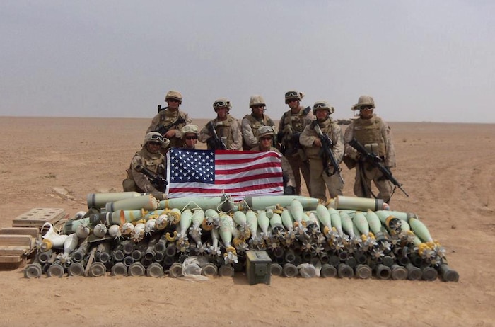 Sgt. Cornelius D. Davis (center, rear), a Chicago native and ammunition technician with Ammunition Company, 2nd Supply Battalion, 2nd Marine Logistics Group, poses with other Marines in front of a munitions cache during his 2012 deployment to Afghanistan. Davis spent seven months in Afghanistan, where he supported Marine units as an ammunition technician. 