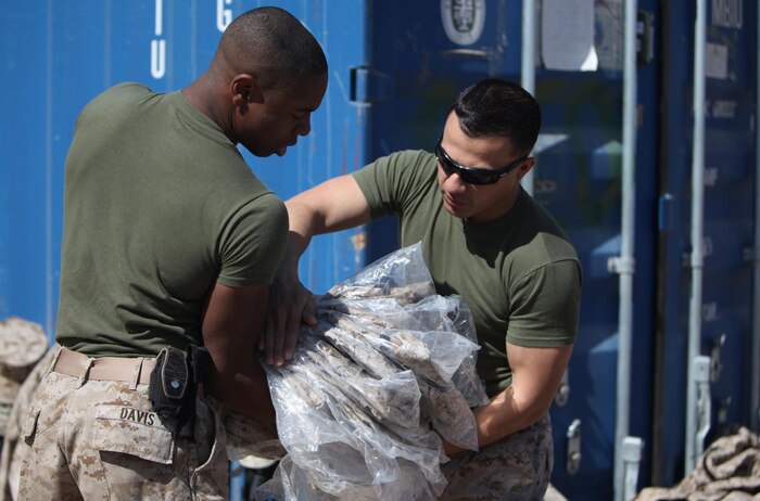 Sgt. Cornelius D. Davis (left), a Chicago native and ammunition technician with Ammunition Company, 2nd Supply Battalion, 2nd Marine Logistics Group, assists another Marine as they organize supplies during a 2012 deployment to Afghanistan. Davis said his passion for leadership found a home in the Marine Corps, and he wants to reenlist to explore more of the opportunities available in the military. 