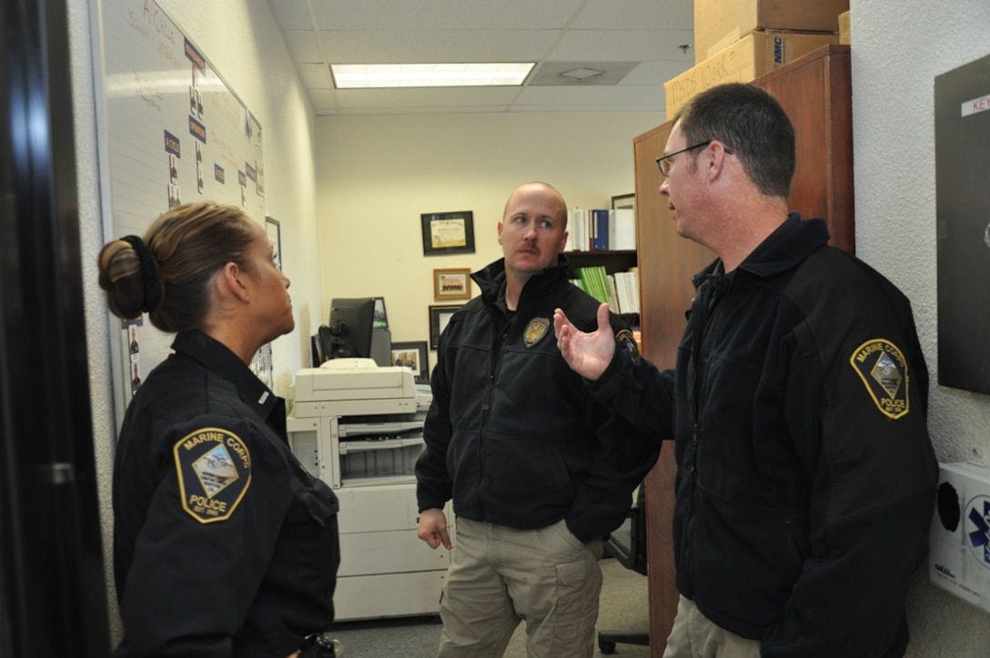 (Left to right) Lieutenant Amy Malinowski, operations chief, Capt. Charles E. MacNeil II, operations officer, and Lt. Justin Witcher, accident investigator supervisor, for the Marine Corps Police Department on Marine  Corps Logistics Base Barstow, discuss the pending  shift rotation for the month of March, Jan. 29. The shift rotation happens every six months to afford each officer schedule flexibility.