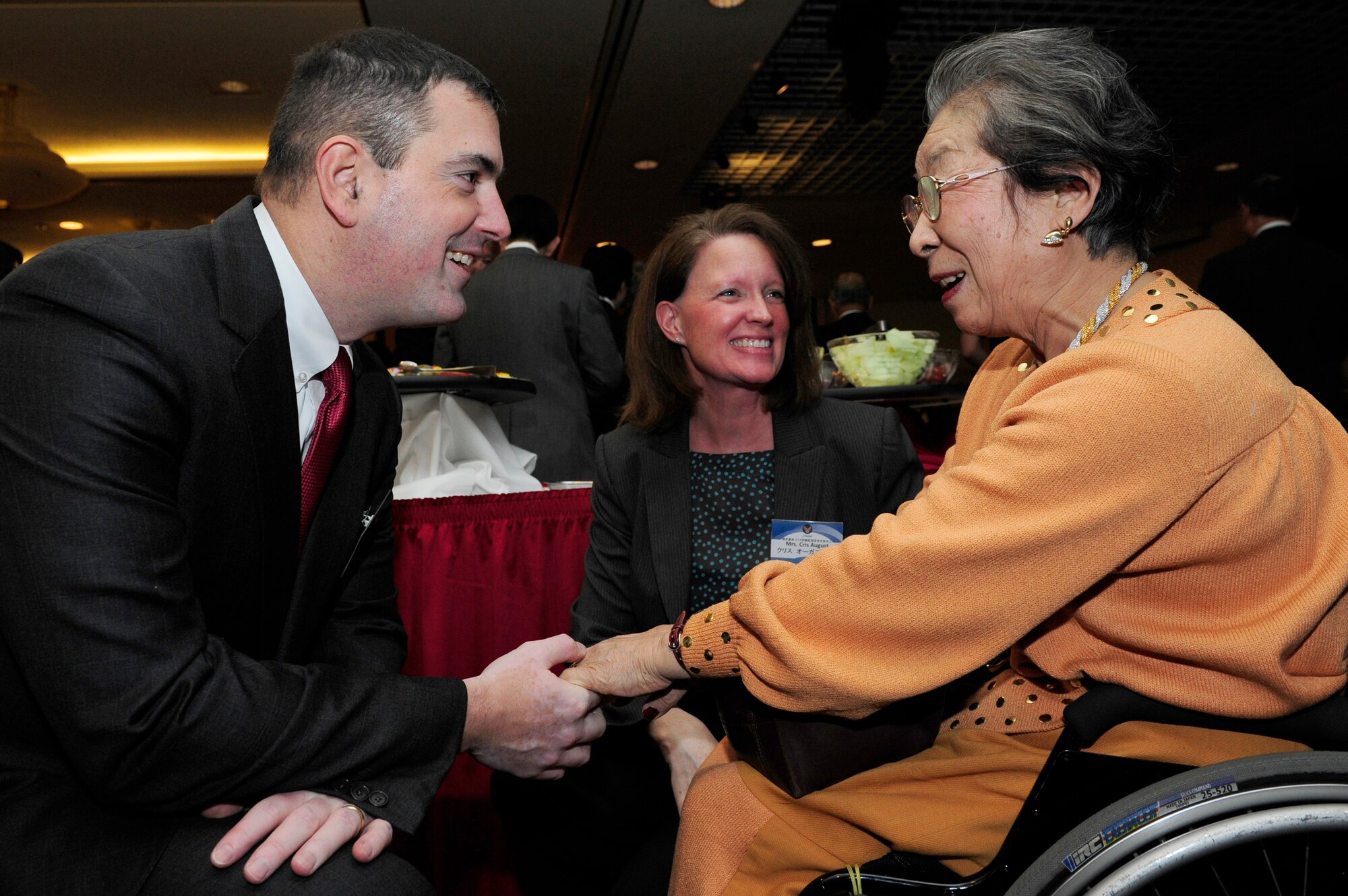 Col. Mark August, 374th Airlift Wing commander, and his wife, Kris, greet Chieko Nishikawa, a member of Akishima-Yokota Friendship Club, at a New Year's celebration hosted at Yokota Air Base, Japan, Jan. 26, 2013. Seven cities surrounding Yokota Air Base--including Fussa, Akiruno, Mizuho, Hamura, Musashimurayama, Ome, and Akashima--have established friendship clubs which partner with the base in order to exchange goodwill. (U.S. Air Force photo by 2nd Lt. Jake Bailey)