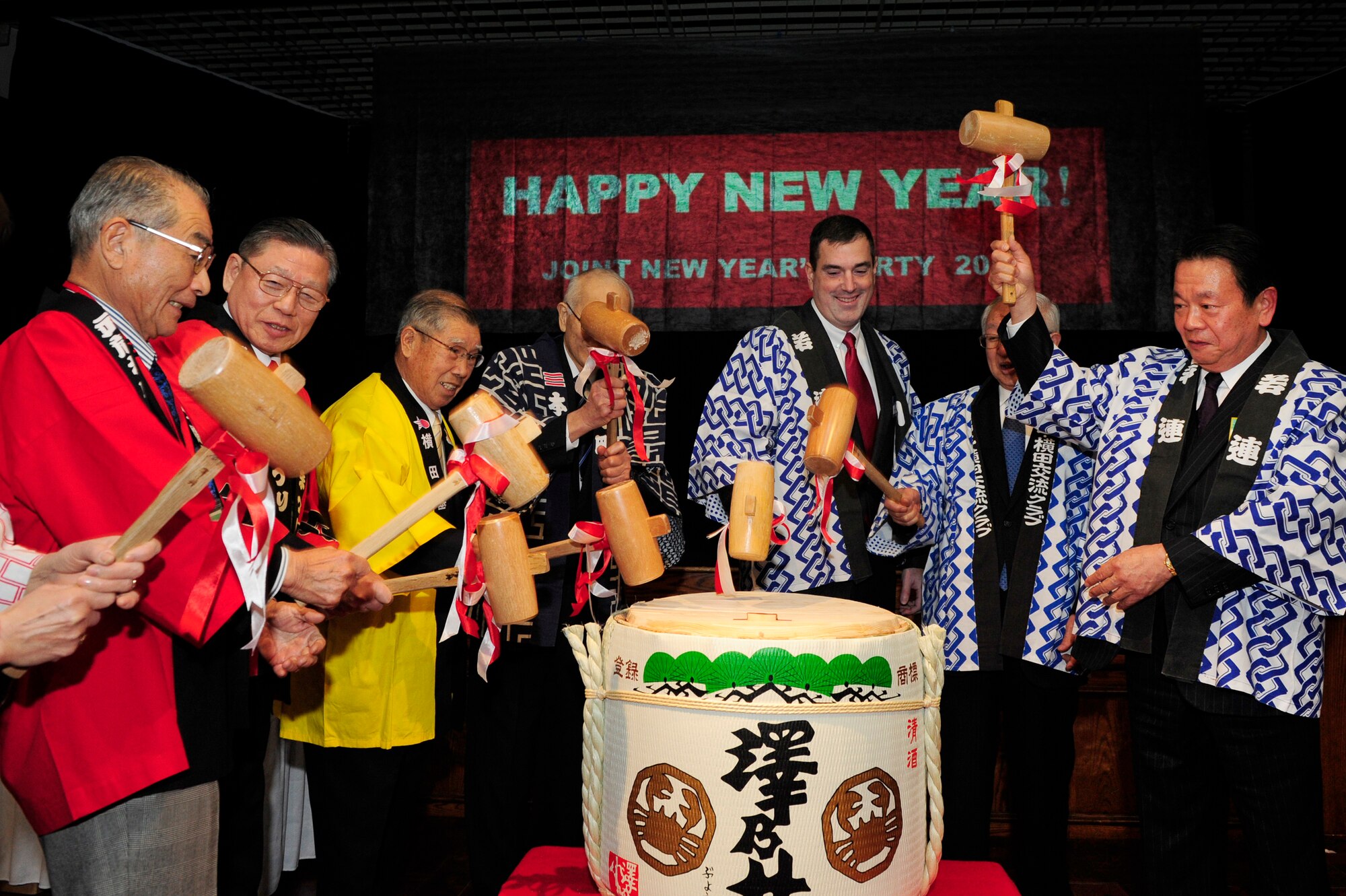 Col. Mark August, 374th Airlift Wing commander, and several friendship club presidents participate in the traditional breaking of the sake keg at a New Year's celebration hosted at Yokota Air Base, Japan, Jan. 26, 2013. Seven cities surrounding Yokota Air Base--including Fussa, Akiruno, Mizuho, Hamura, Musashimurayama, Ome, and Akashima--have established friendship clubs which partner with the base in order to exchange goodwill. (U.S. Air Force photo by 2nd Lt. Jake Bailey)