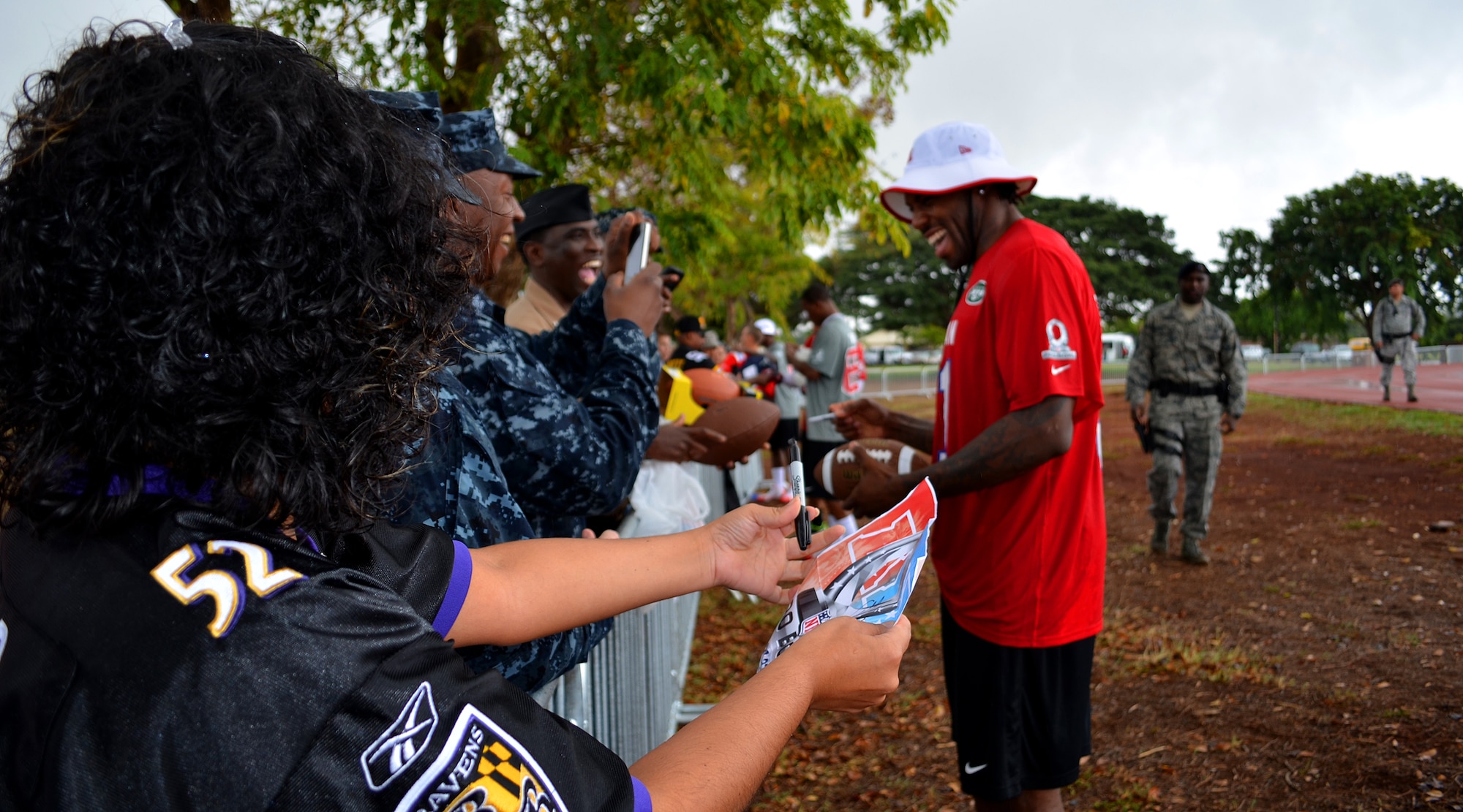 Joint Base Pearl Harbor-Hickam service members and their families’ take pictures and get football memorabilia signed by National Football League Pro Bowl player Antonio Cromartie of the New York Jets and others players at Earhart Field, JBPHH, Hawaii, Jan. 24, 2013. Thousands of military service members and their families gathered to catch a glimpse of their favorite NFL stars as they practiced in preparation for Sunday's Pro Bowl. (U.S. Air Force photo/Tech. Sgt. Jerome S. Tayborn)
