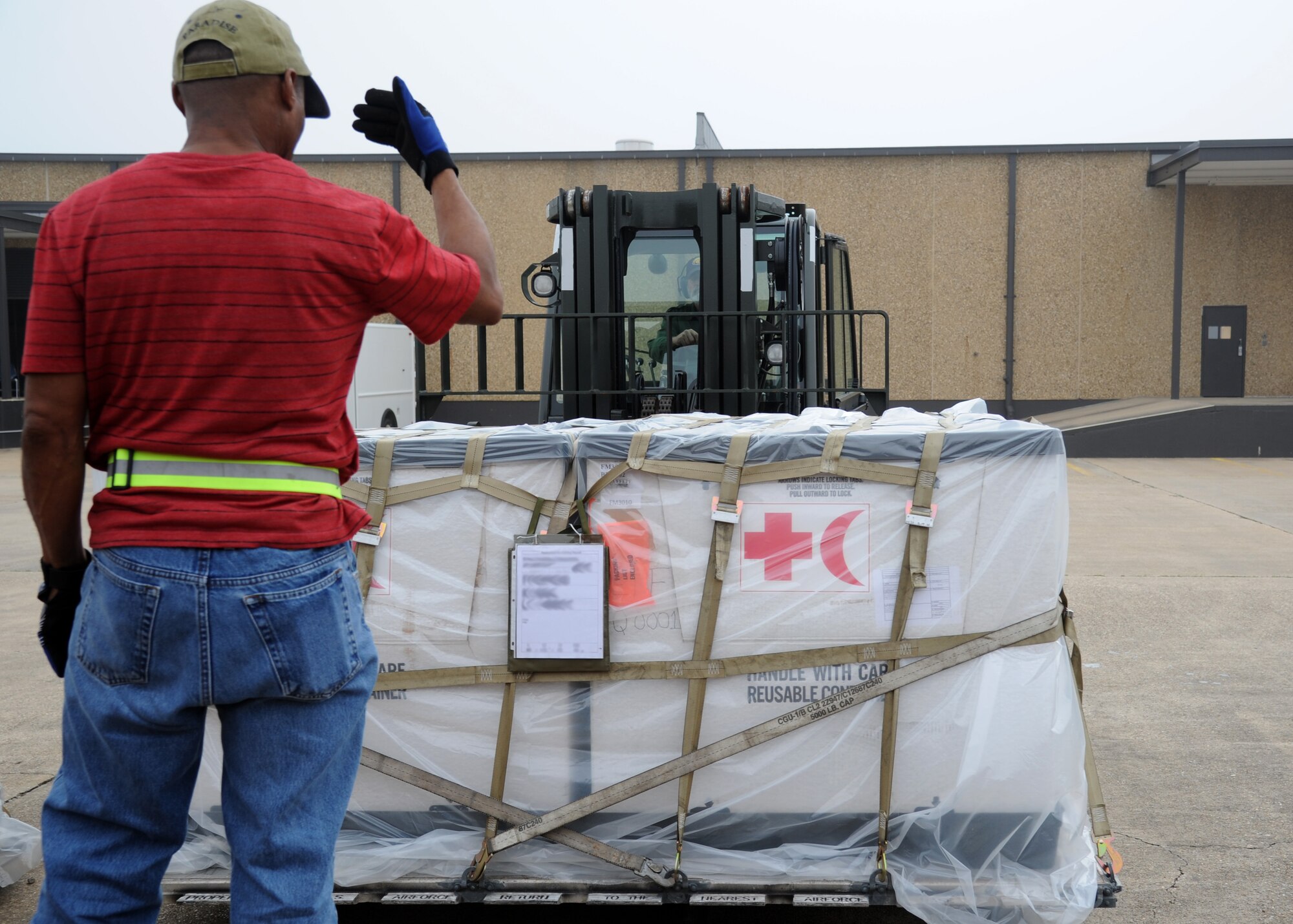 Gary Harmon, 81st Logistics Readiness Squadron, provides direction to Marc Lerch, 81st LRS, as he operates a forklift for transporting cargo at the supply warehouse loading docks during a humanitarian deployment exercise Jan. 29, 2013, at the Taylor Logistics Center, Keesler Air Force Base, Miss.  The exercise scenario consists of an earthquake in Arkansas with a warning order for a deployment to Little Rock, Ark.  (U.S. Air Force photo by Kemberly Groue)